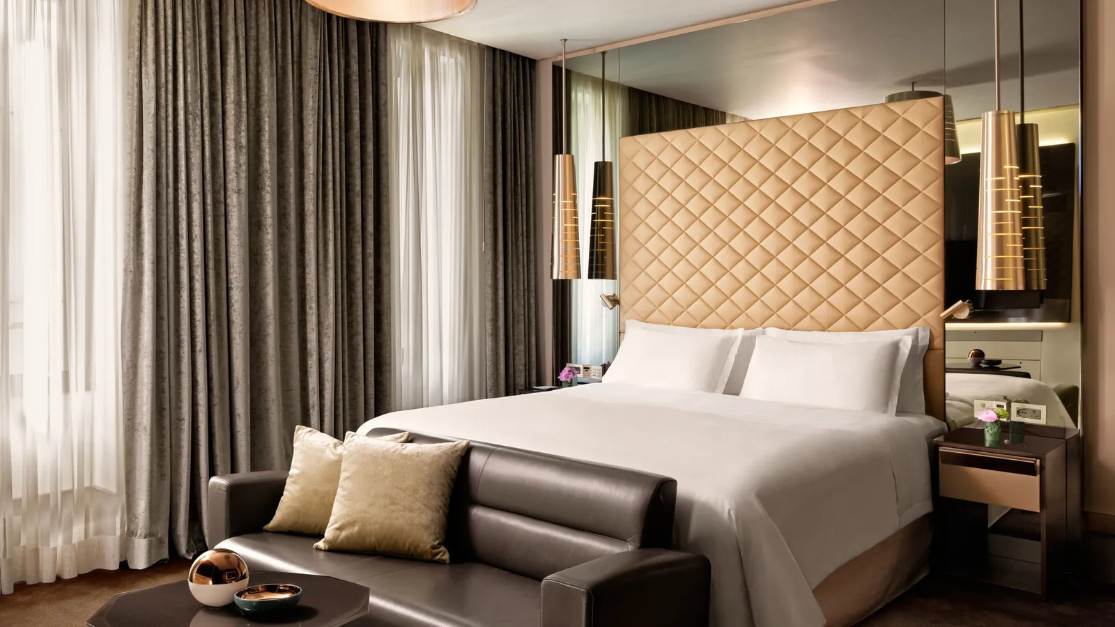 A Premium room, with its quilted headboard, a sofa and the curtains