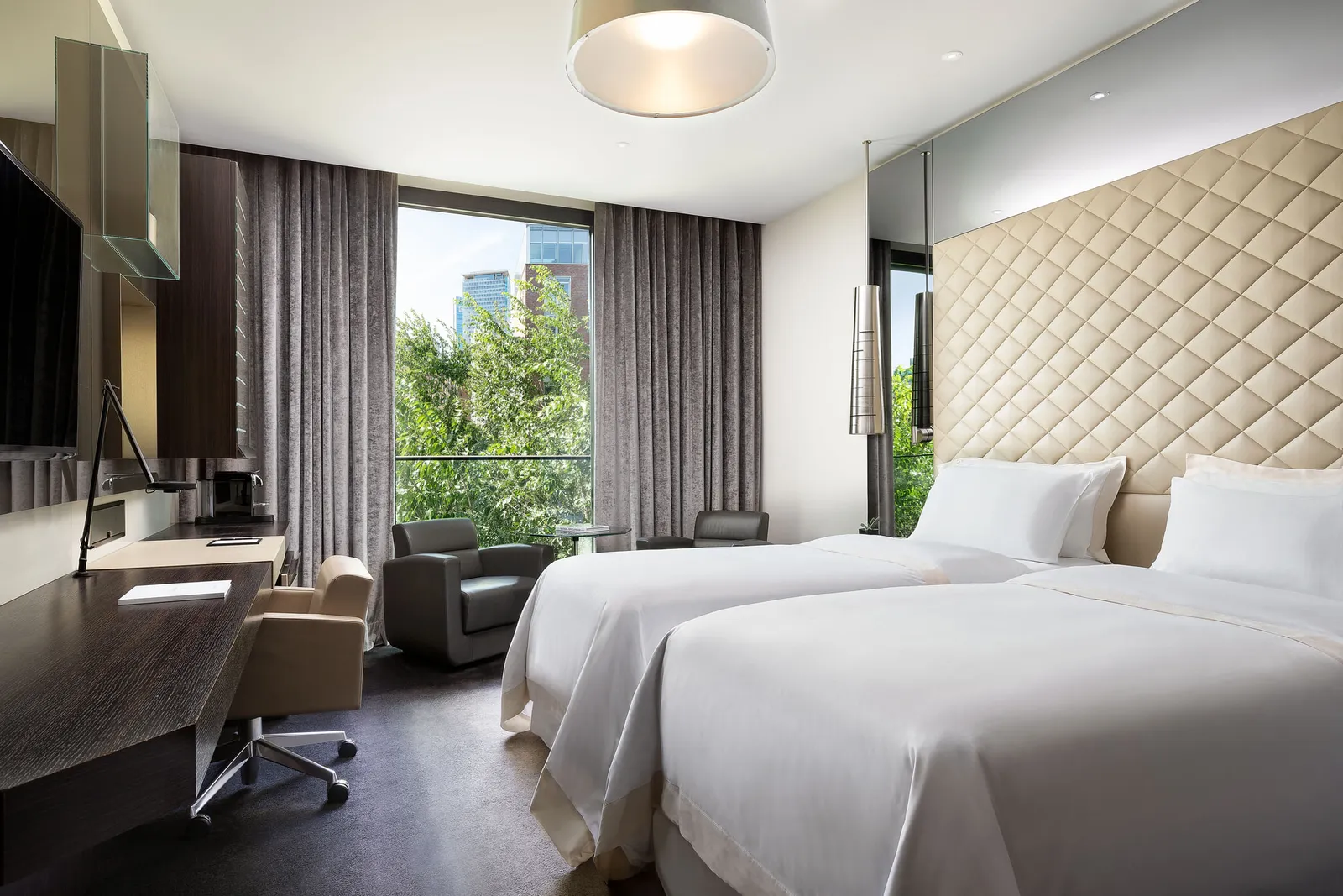 A Prestige room with 2 single beds and the window on the trees
