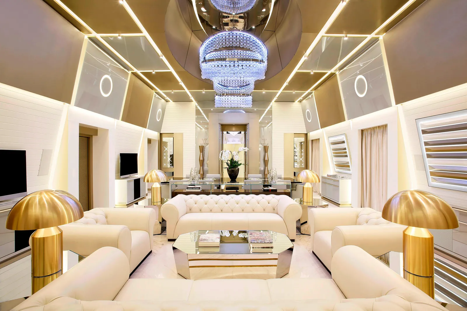 The living room of the Katara Royal Suite, under crystal chandeliers, with white sofas and gold lamps