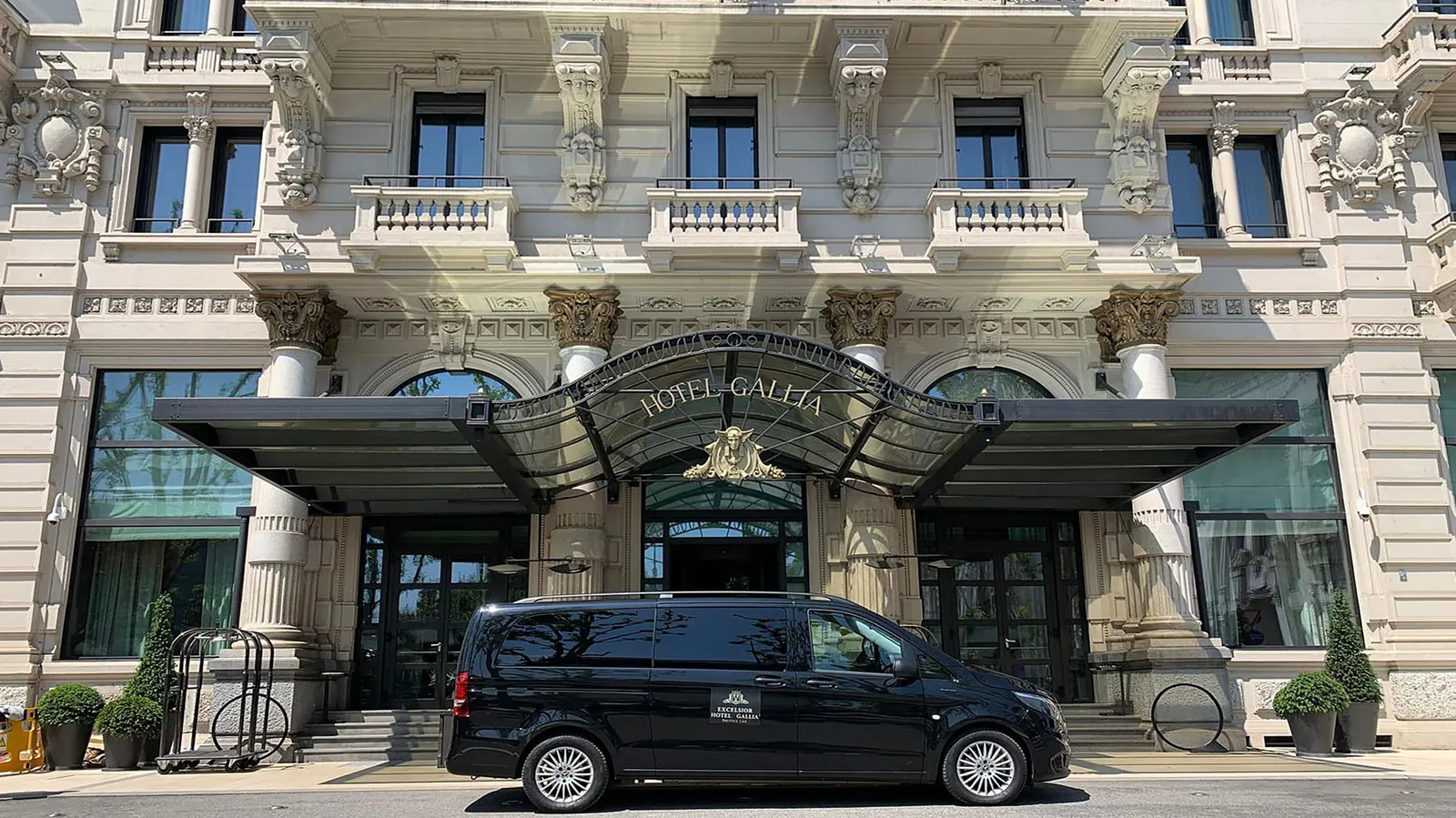 The hotel’s black shuttle van parked in front of the canopy on Piazza Duca d’Aosta