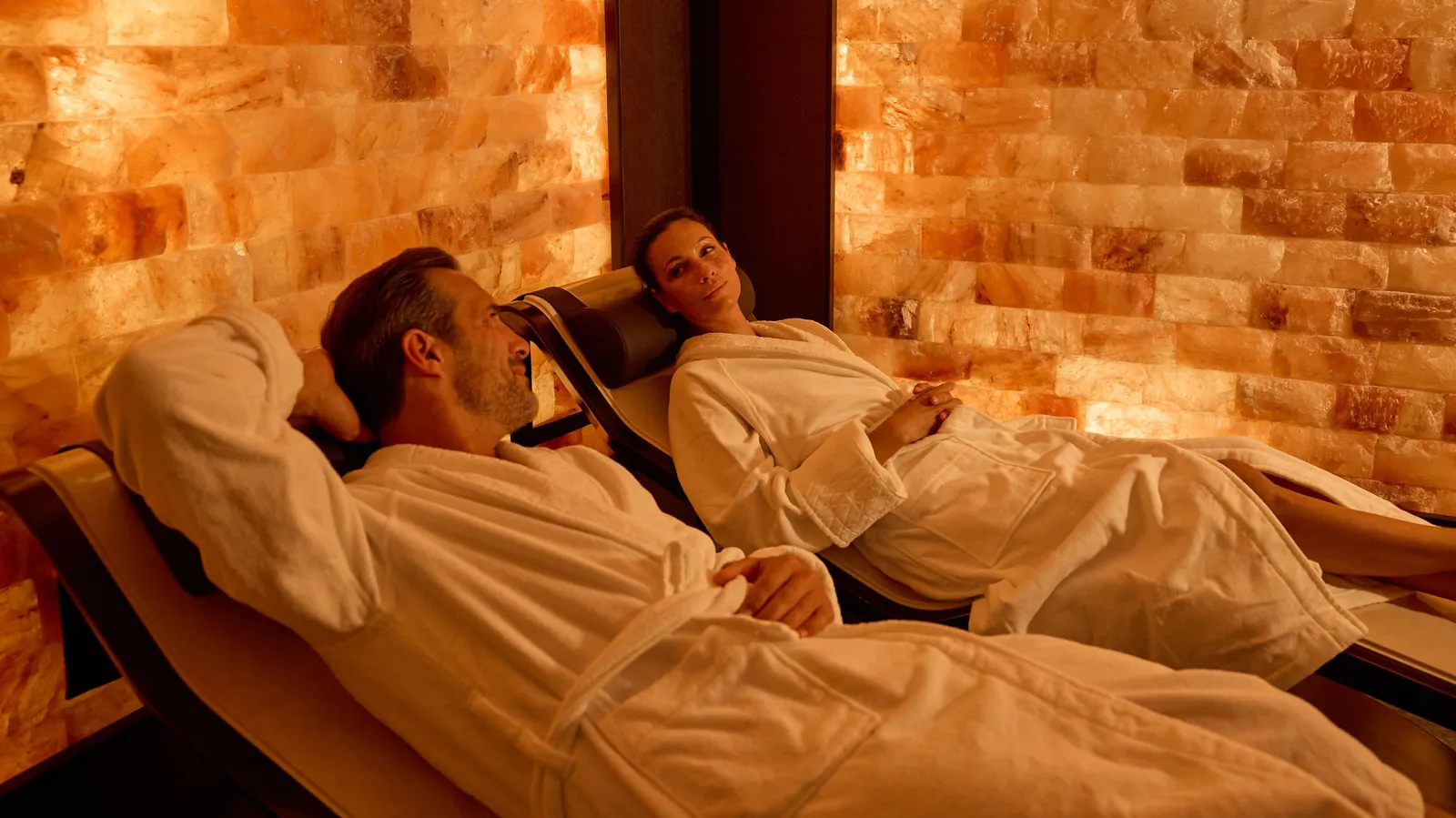 2 guests in bathrobes on the loungers of the Himalayan salt room