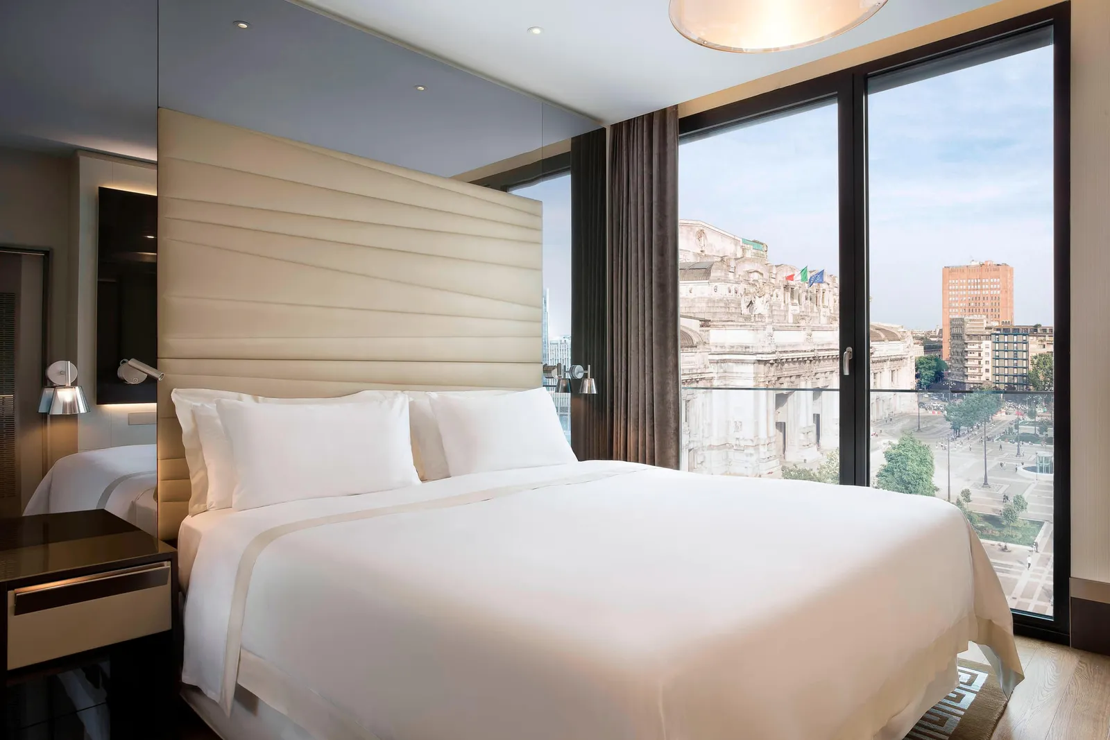 The bedroom of an Atelier Suite, with Milano Centrale beyond the window