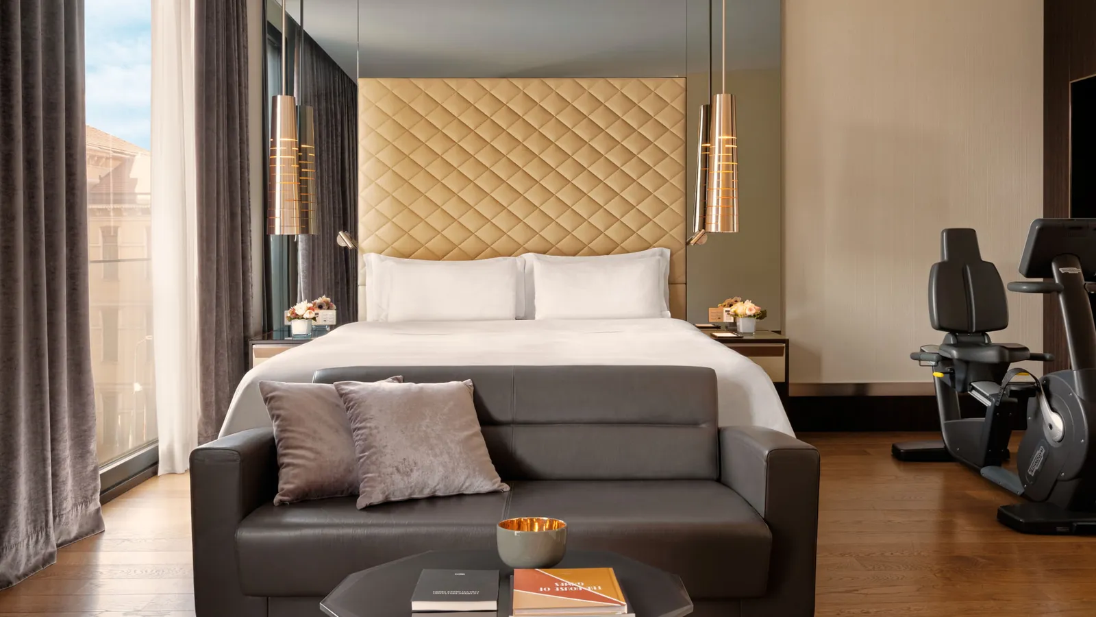 The bedroom of an Executive Suite, with an exercise bike by the window