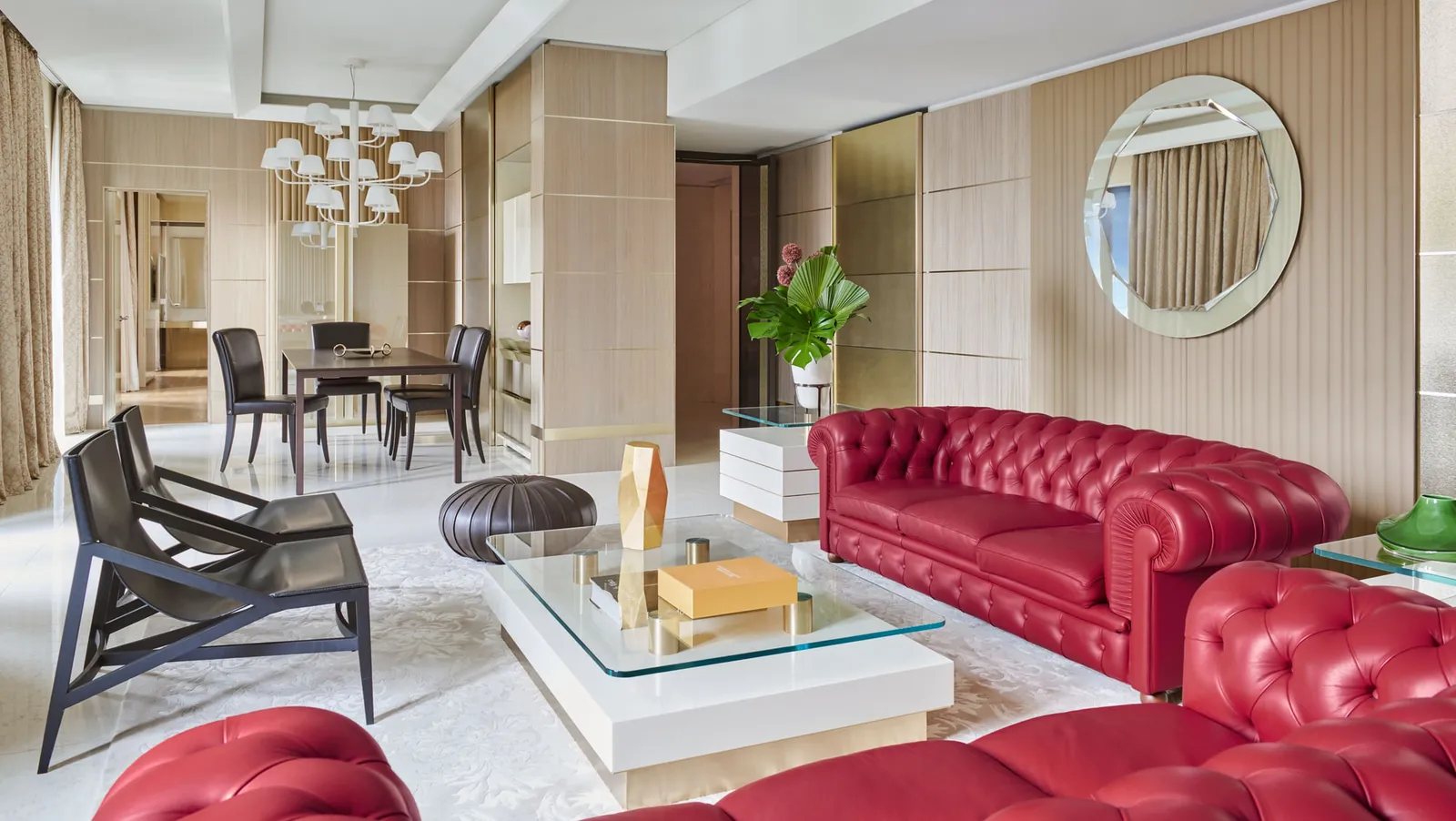 The living room of the Gallia Presidential Suite, with red leather sofas and a white rug