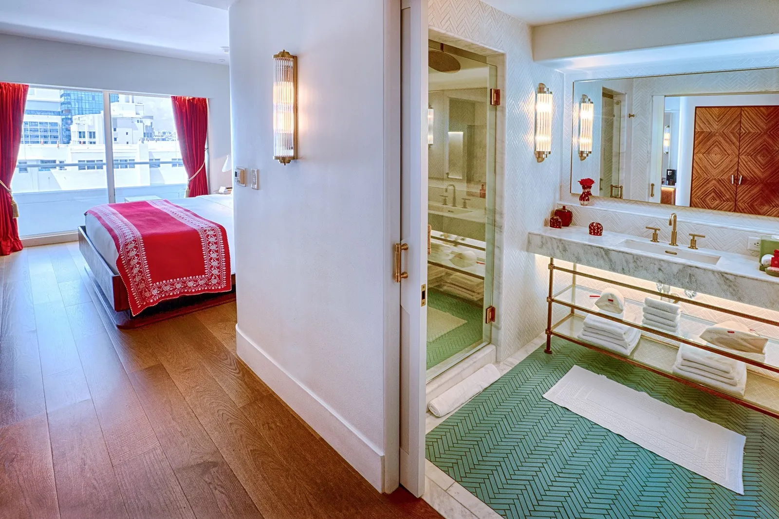 A Partial Ocean View Room: the bed with its red cover and, through the door, the marble bathroom with a turquoise floor.