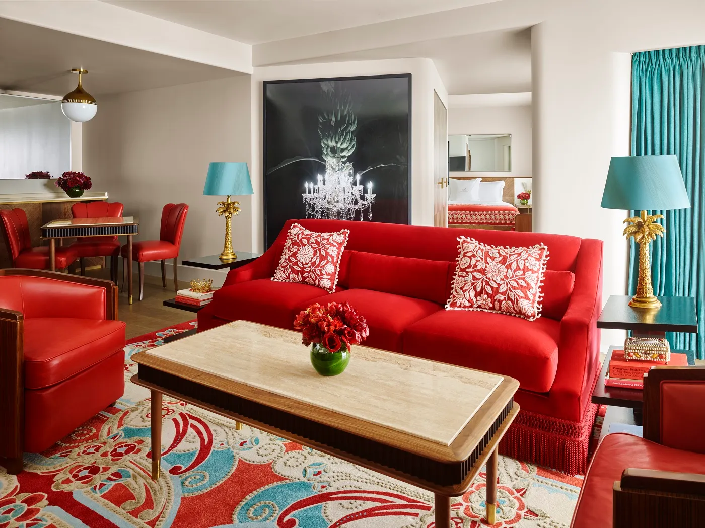 The Partial Ocean View Suite’s living room: the red sofa with flowered cushions, a stone coffee table and the dining table beyond.
