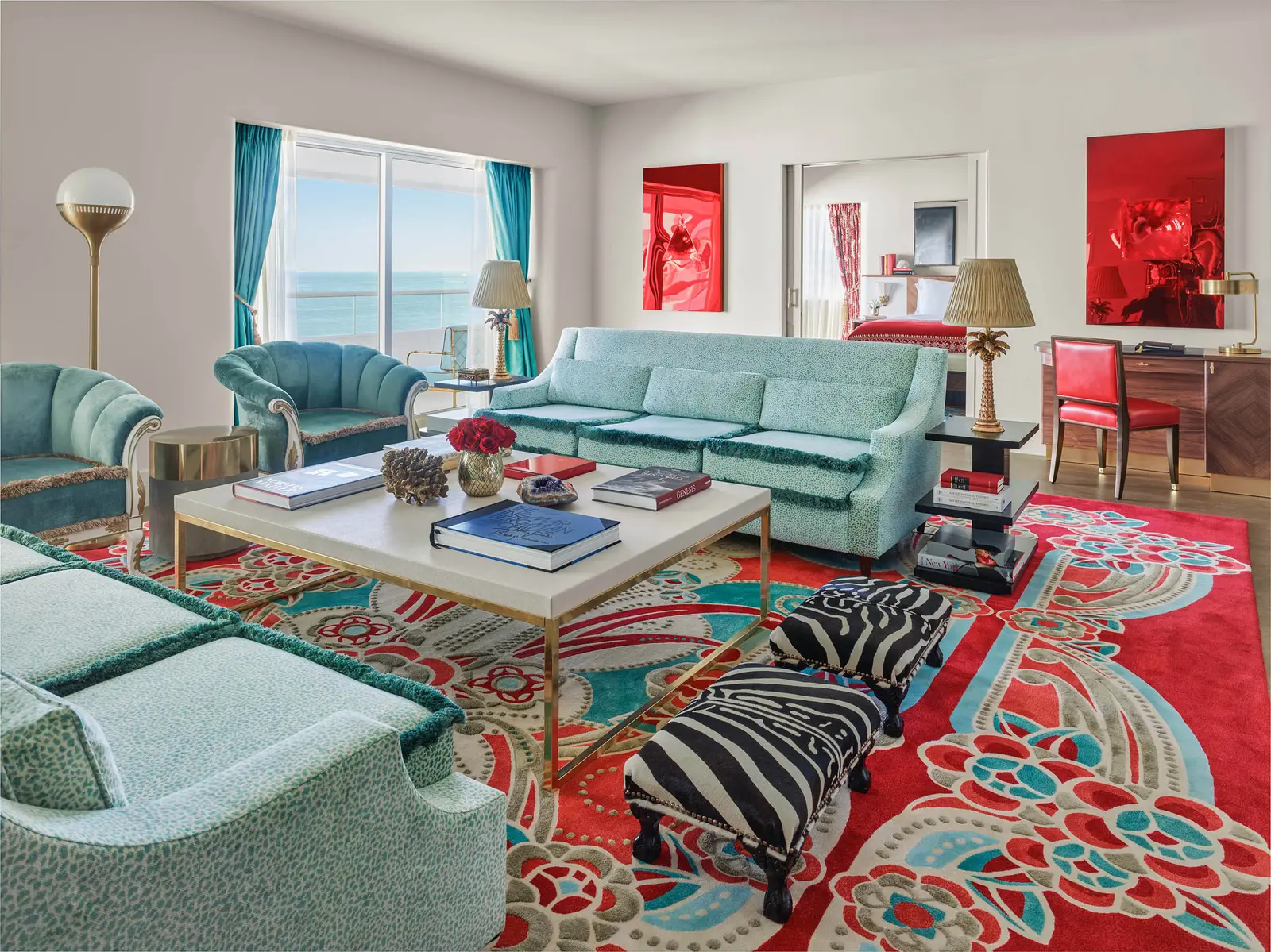 The Saxony Suite’s living room: pale turquoise sofas, a zebra-print bench, a red carpet and turquoise curtains.