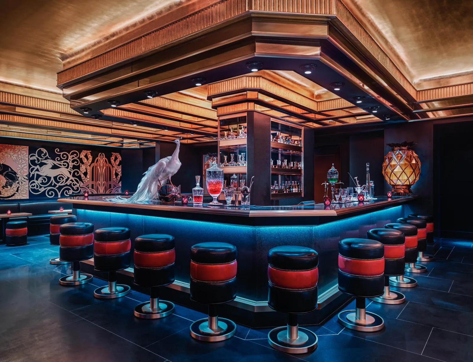Saxony Bar: the octagonal counter lit in blue, red stools and a white peacock on the bar.