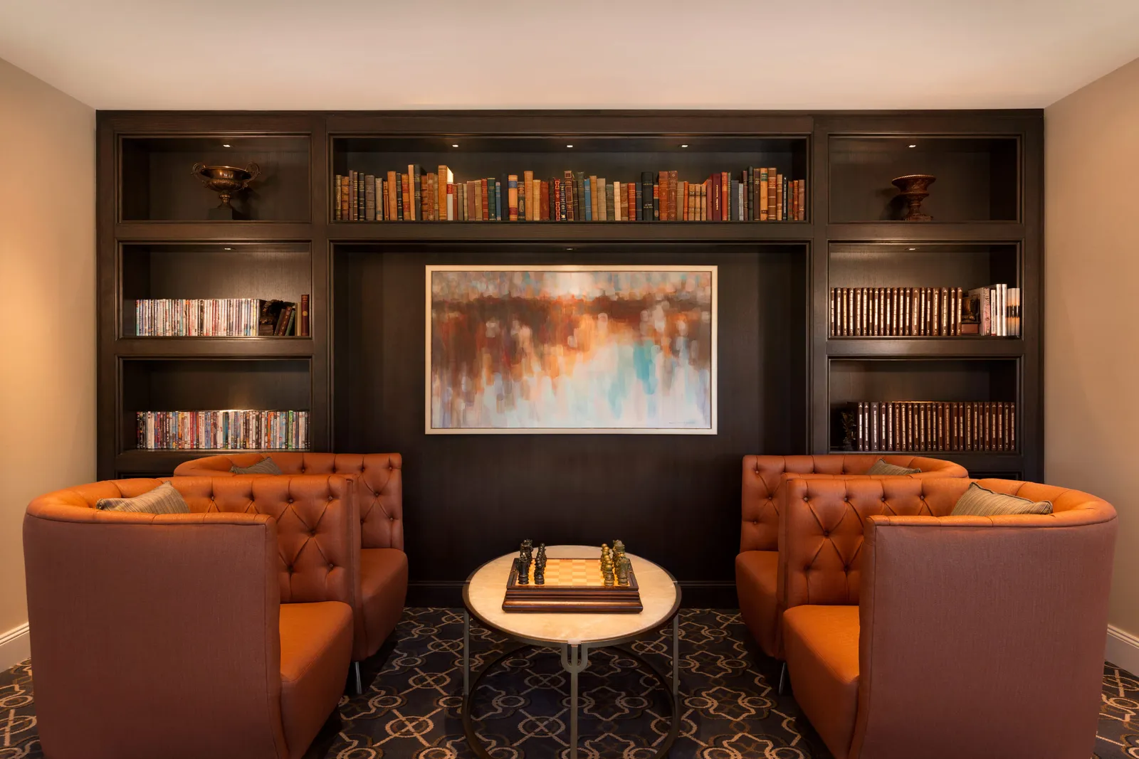 Armchairs and bookshelves around the Gold lounge’s fireplace