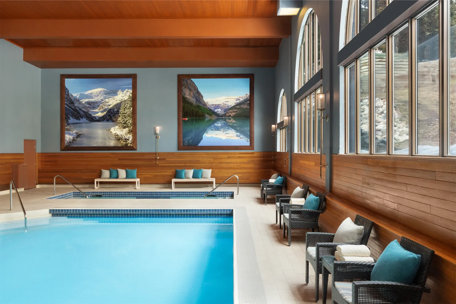 The indoor pool beneath wooden beams, with mountain-facing windows