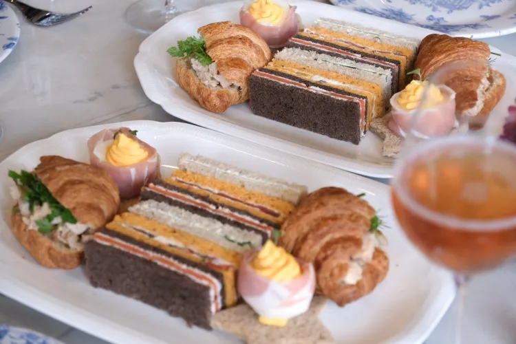 Afternoon tea sandwiches, scones and cakes on a tray