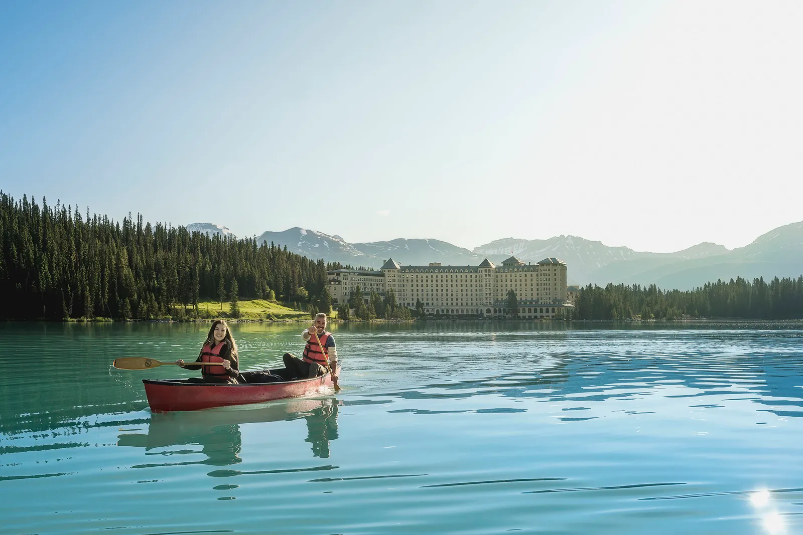 A red canoe on Lake Louise, with the Chateau across the water