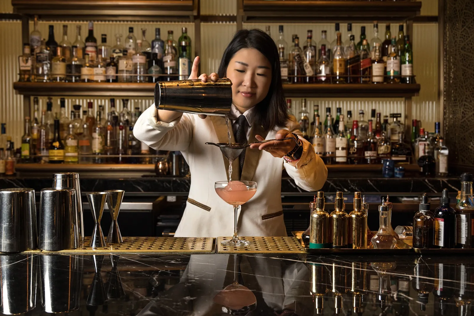 Una barista prepara un cocktail al CLOCKWORK