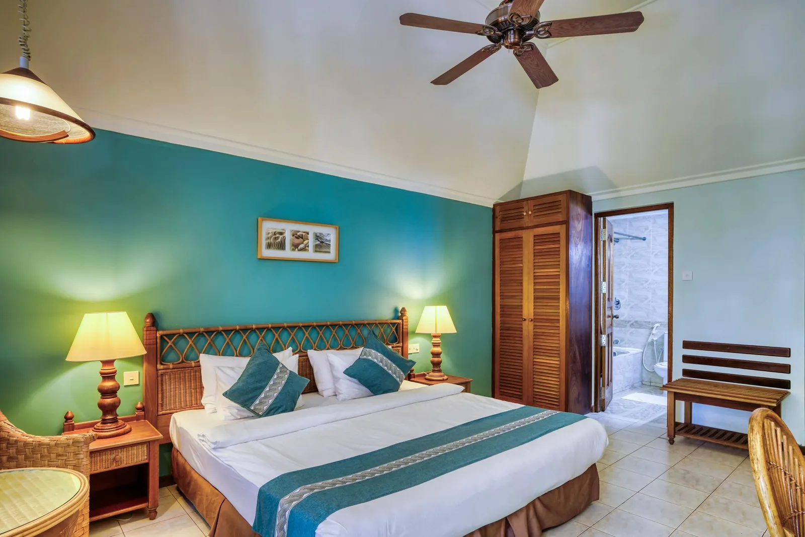 An upstairs Deluxe Sky: the king bed under the sloping ceiling, the fan and the bathroom at the back.