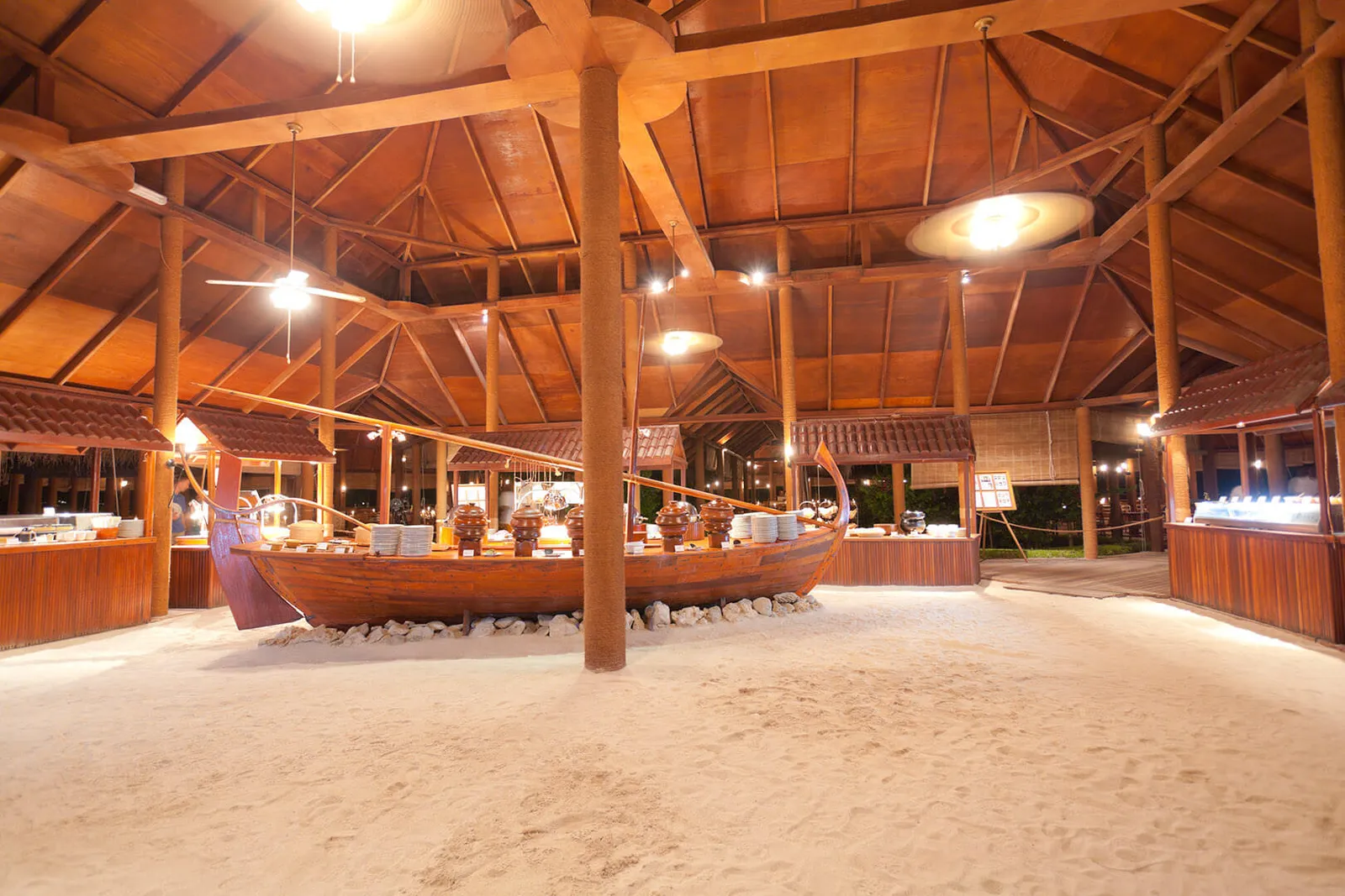 The Main Restaurant: the great timber pavilion with its sand floor, the buffet counters and a dhoni used as a table.