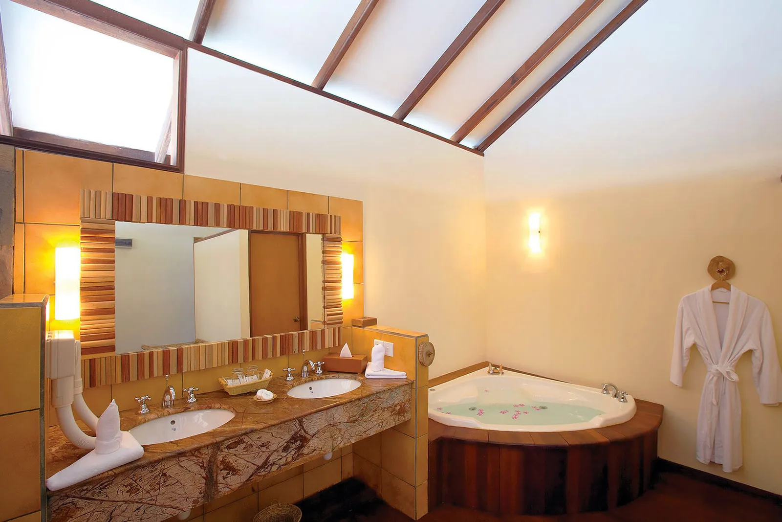 A Water Villa bathroom: the double stone basin, the mirror and the corner jacuzzi bath.