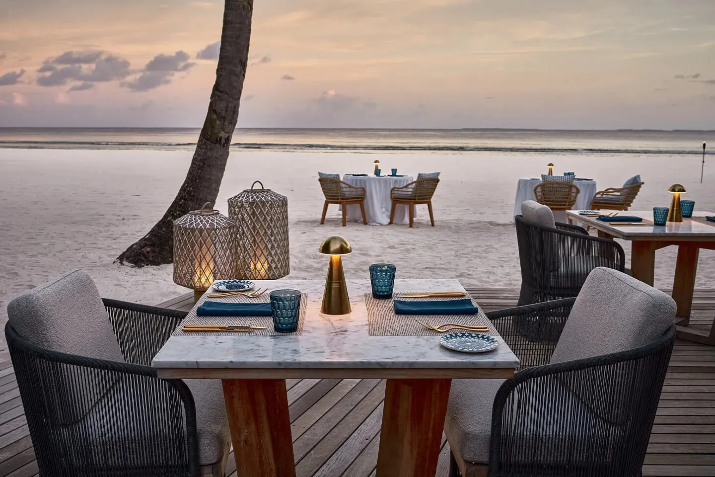 An Arabian Grill table on the deck by the sea, at sunset
