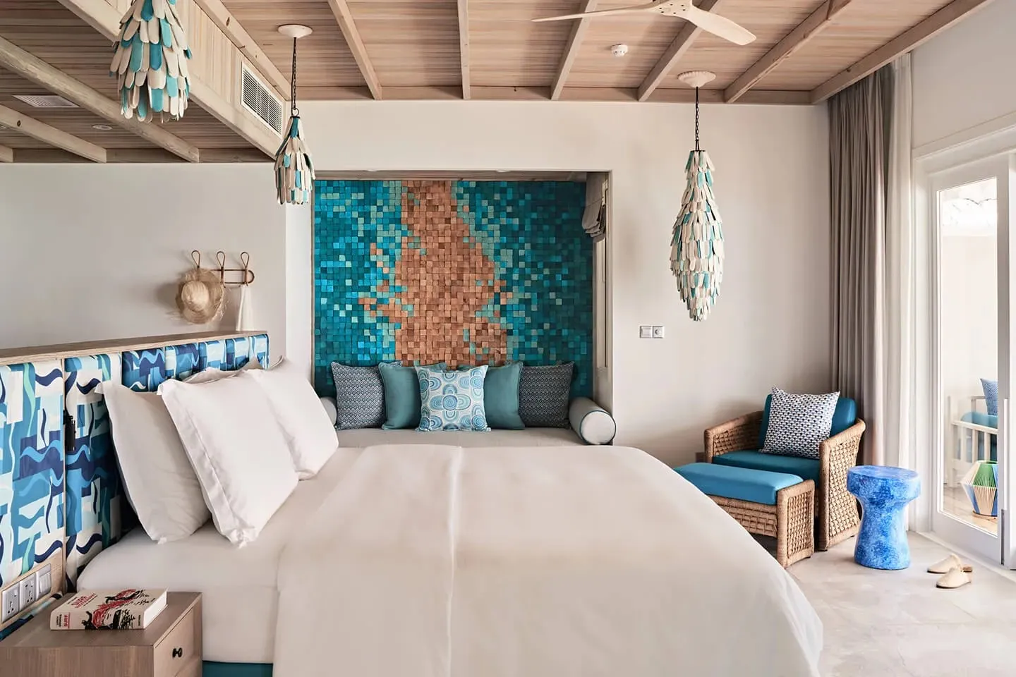 A Lagoon Villa bedroom, the bed beneath a blue and orange mosaic