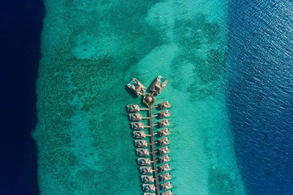 The water villas in a line along their jetty, between the pale lagoon and the deep blue