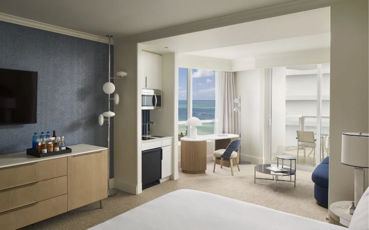 A Trésor Ocean View Junior Suite: the kitchenette with its microwave, the desk, the sitting area and the sea beyond the far window.