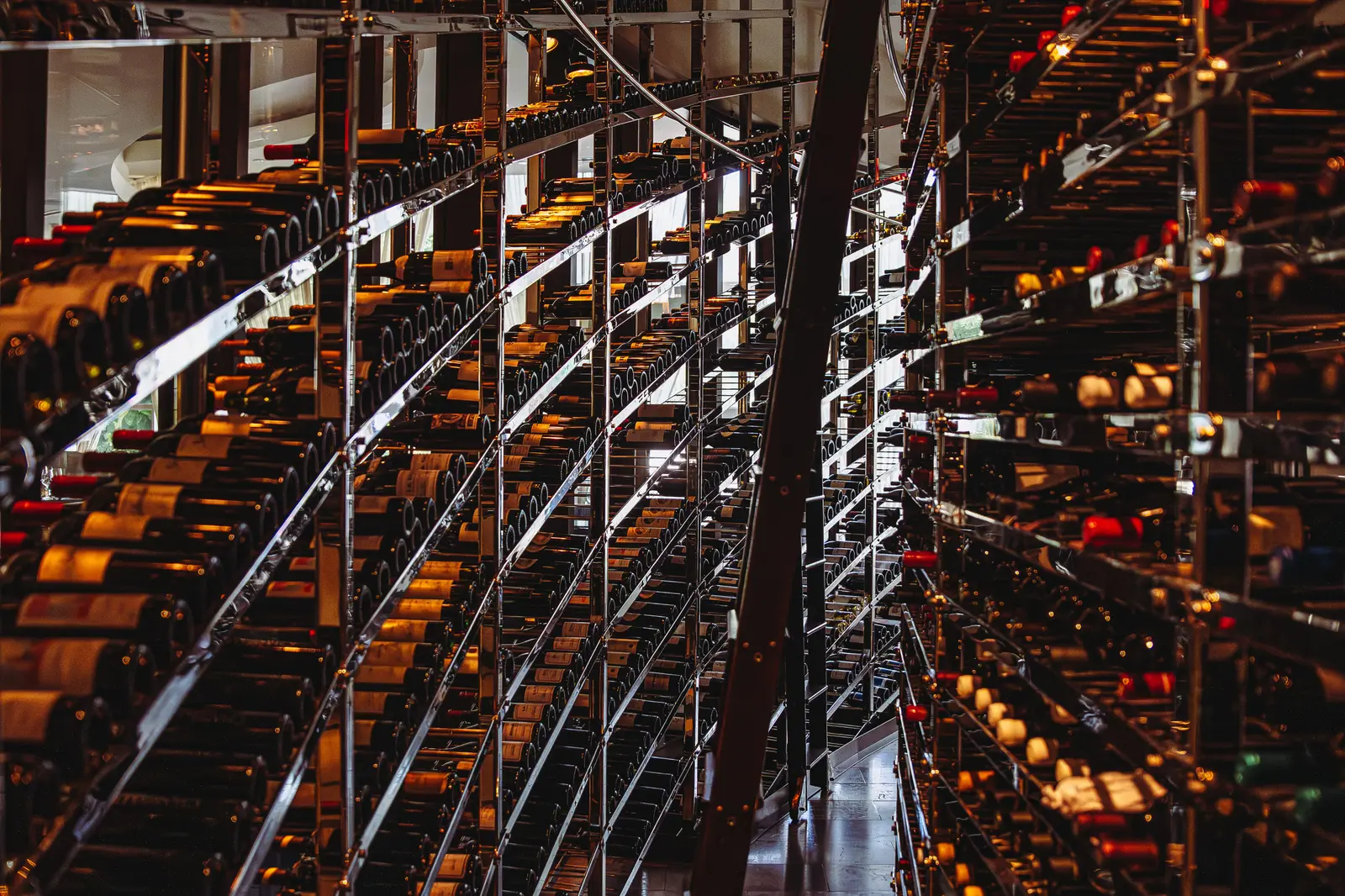 The wine vault, its bottles lying on metal racks from floor to ceiling.