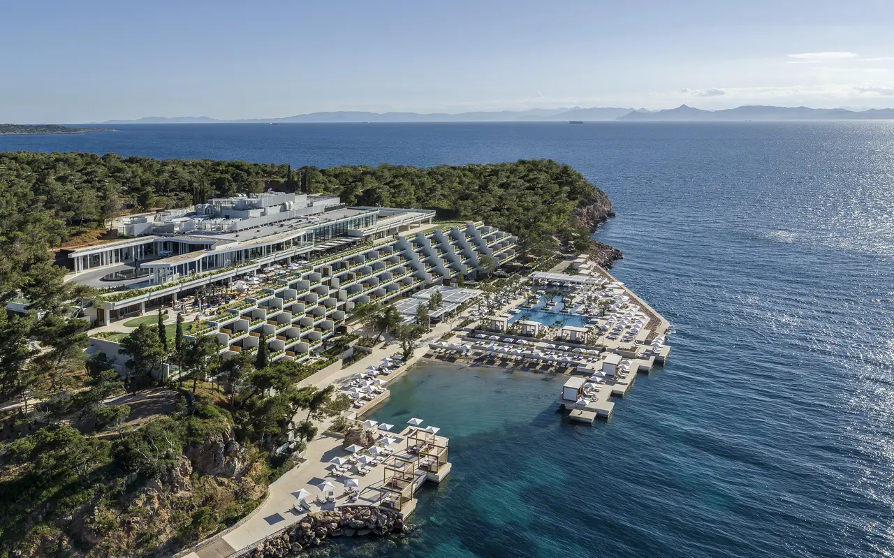 The Nafsika building from the air, stepped down through the pines, with its pool, sun decks on the water and open sea around.
