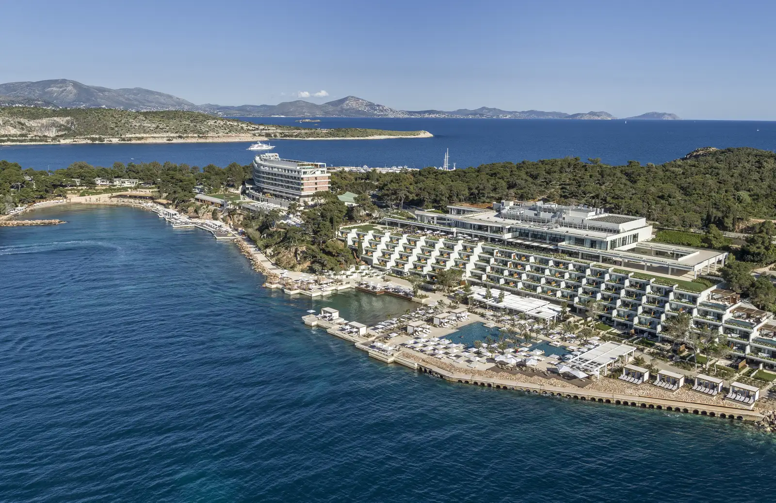 The hotel’s 2 buildings seen from the sea: terraced Nafsika in front with its pool and decks, Arion further back on the bay.
