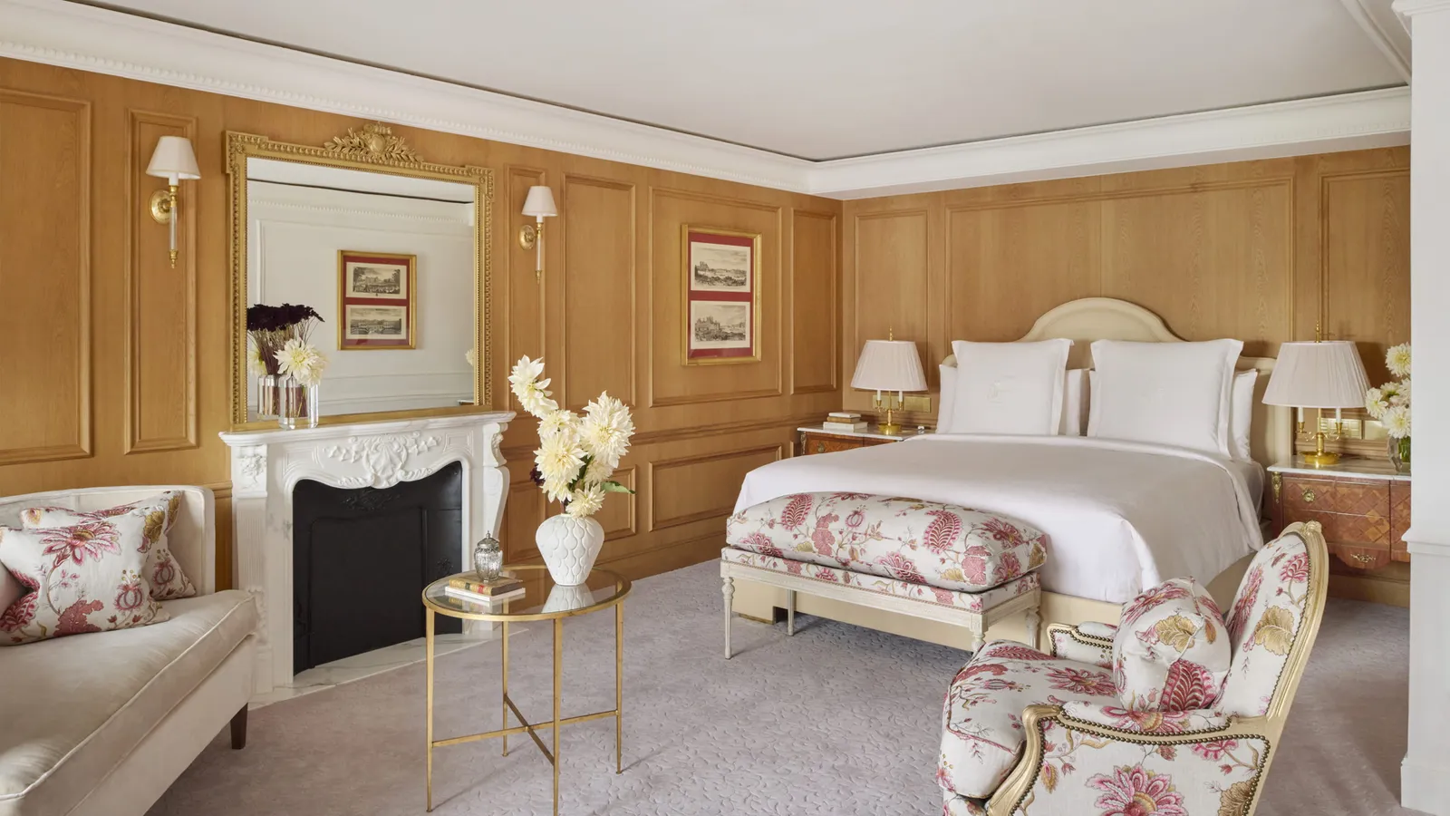 A bedroom with wooden walls and an armchair at the foot of the bed