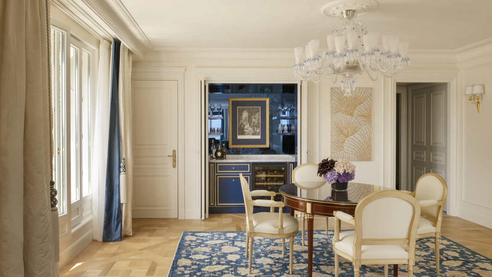 A sitting room with a blue rug, fireplace and round table