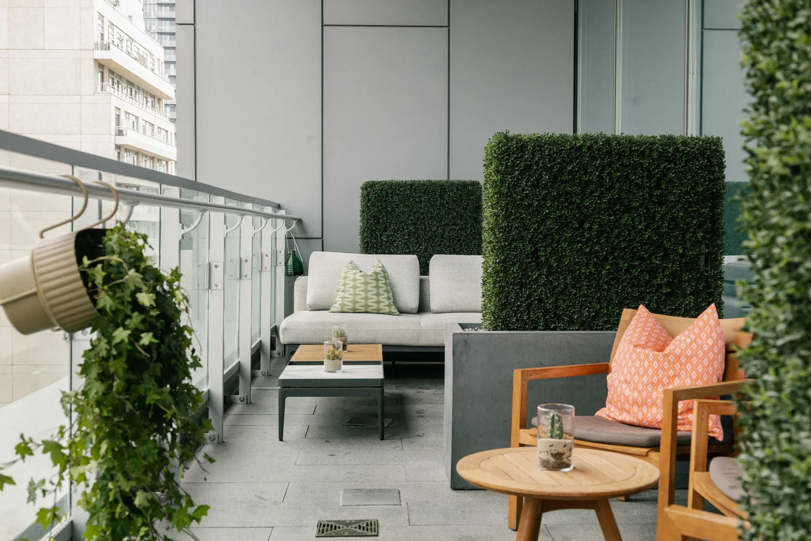 Una nicchia della terrazza con sedute chiare e siepi