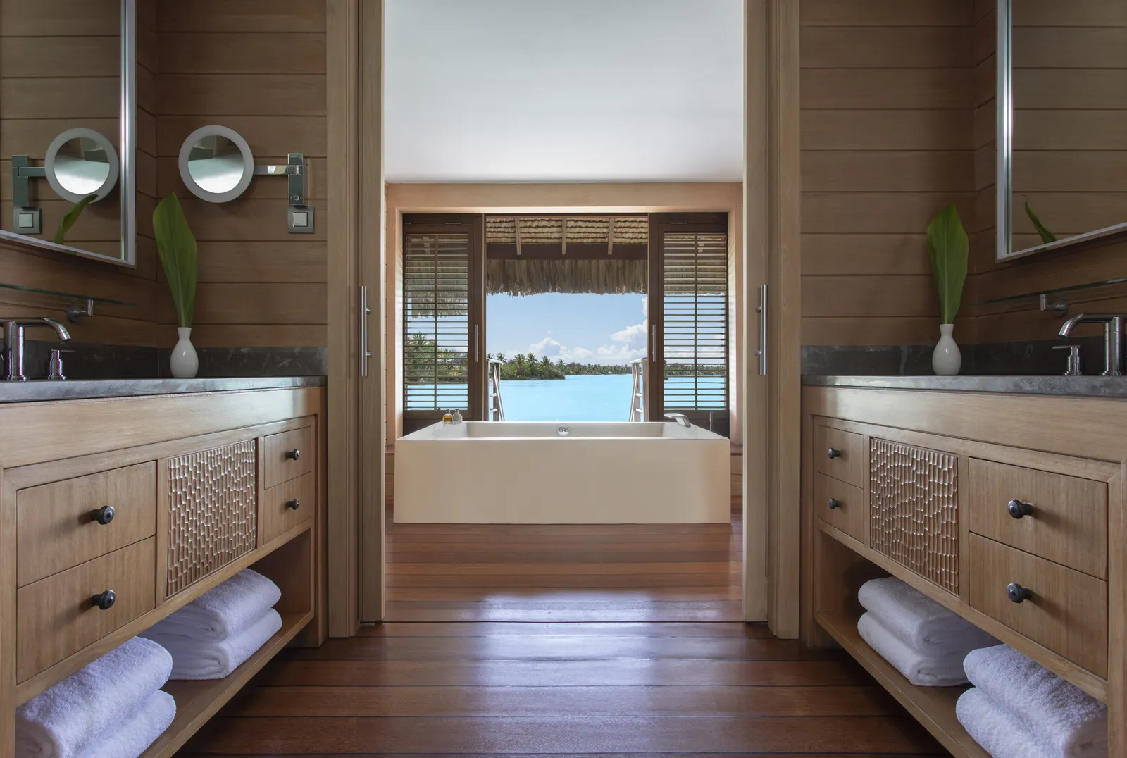 The bathroom, 2 timber vanities and a tub facing a window onto the lagoon