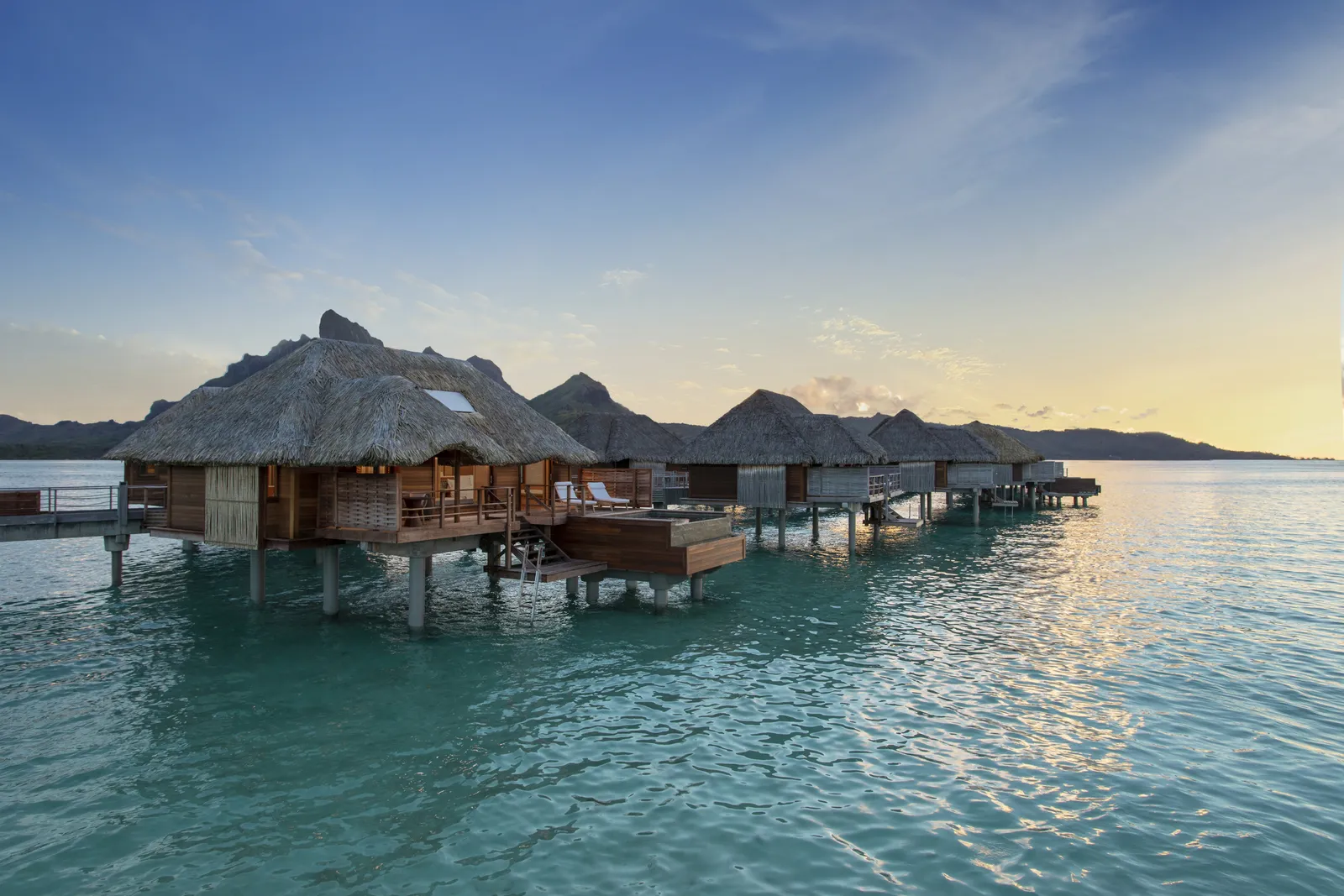Overwater bungalows at sunset, Mount Otemanu behind