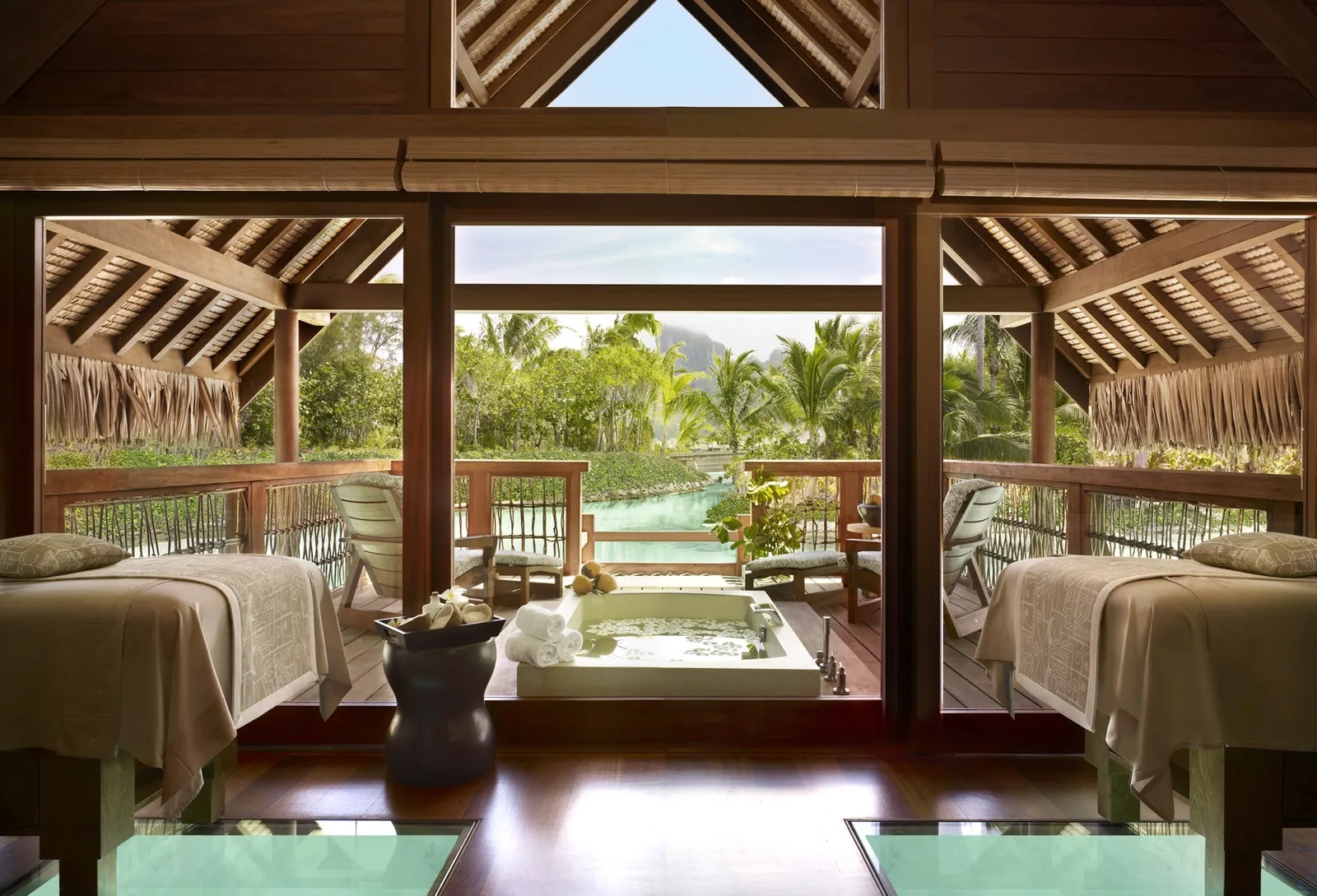 A treatment room for 2 with glass floor panels and a bath, open to the garden