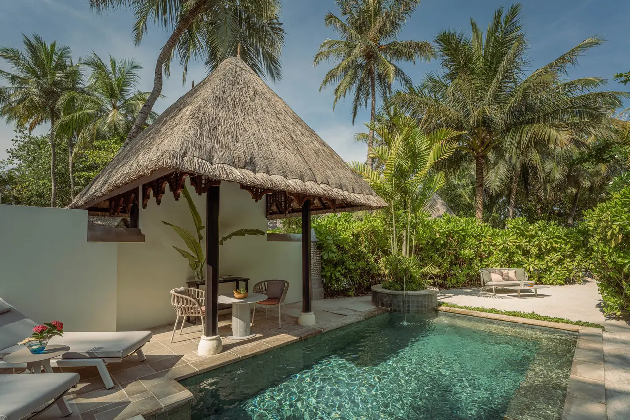 A Garden Pavilion’s pool among the palms, with its thatched pavilion