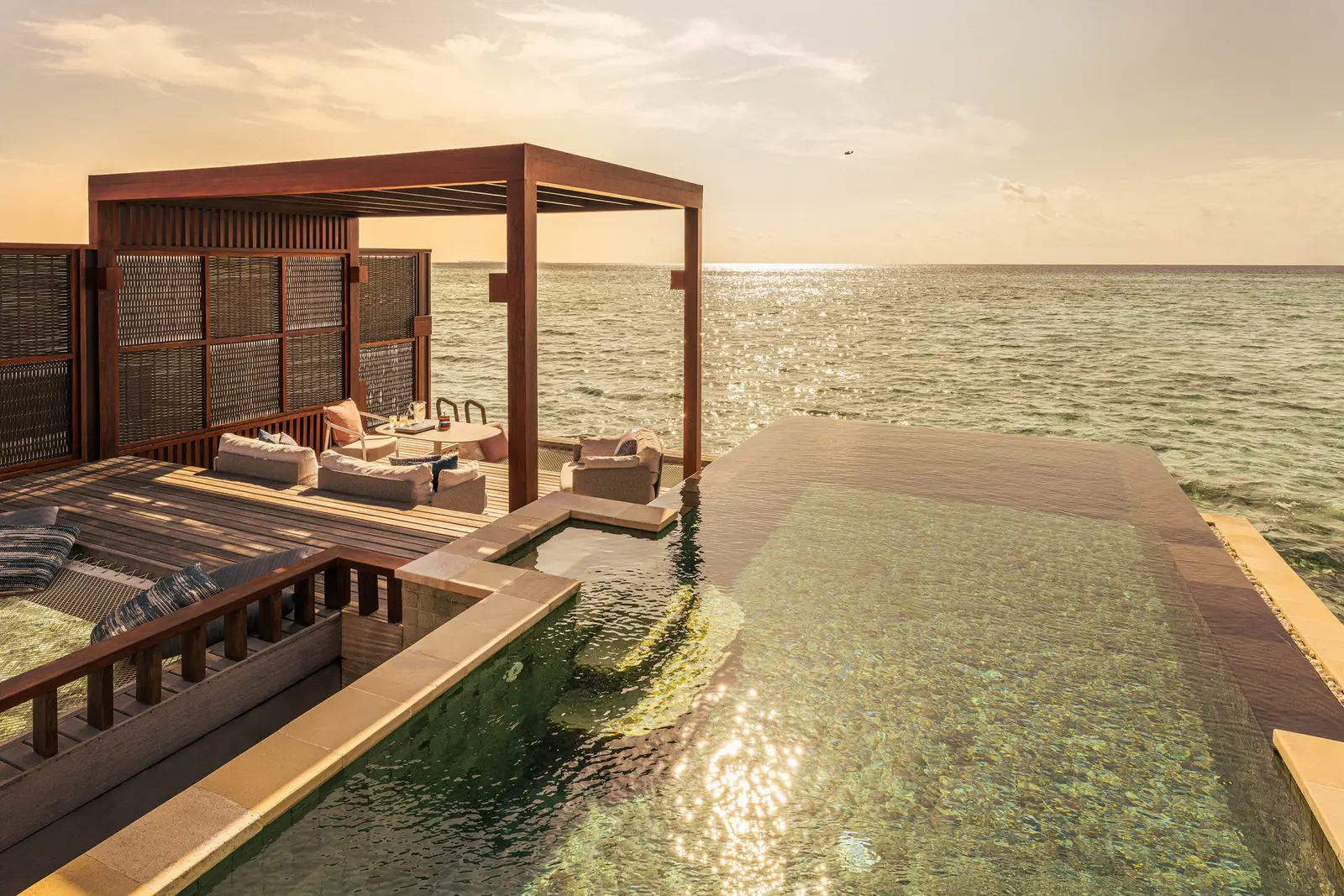 A Sunset Water Villa’s pool over the sea, with its wooden gazebo