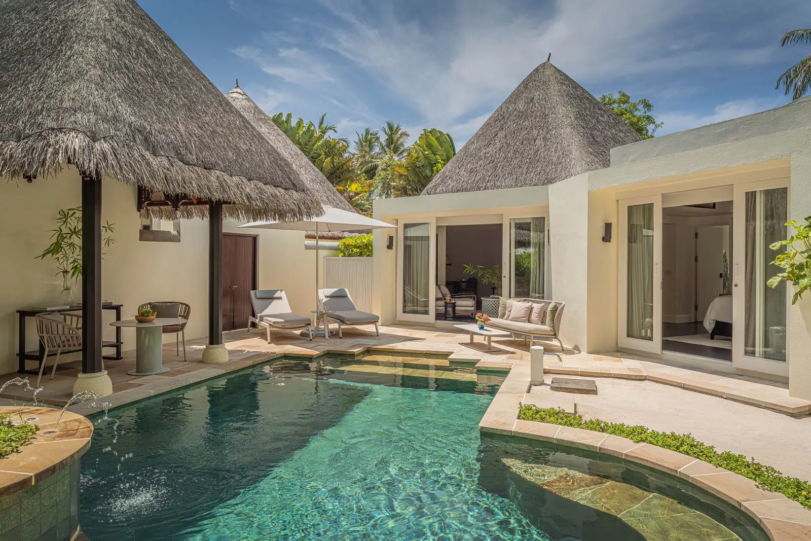 The Two-Bedroom Beach Pavilion’s pool between its 2 white pavilions