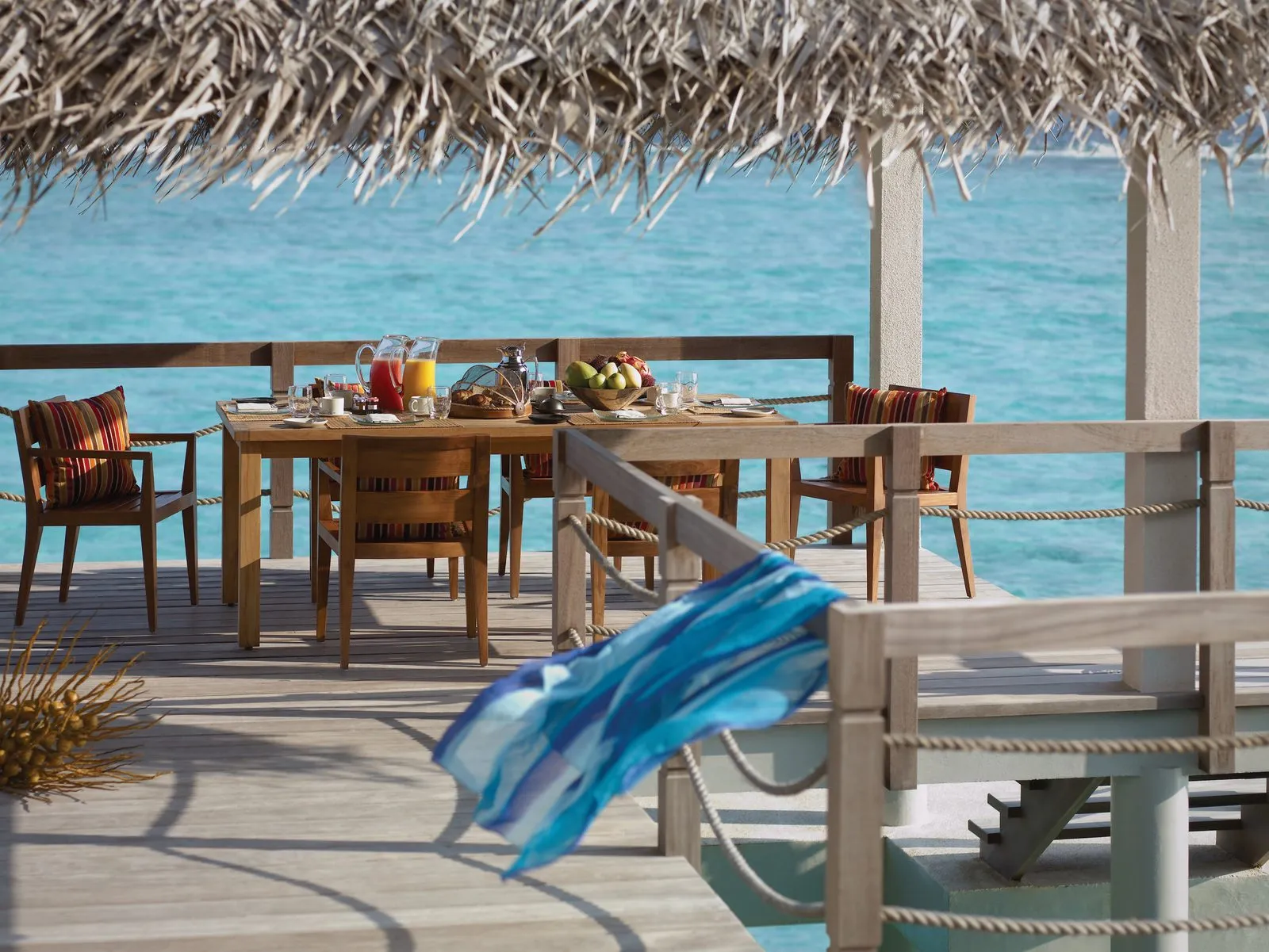 The table laid on the deck of the Three-Bedroom Land and Ocean Suite, above the sea