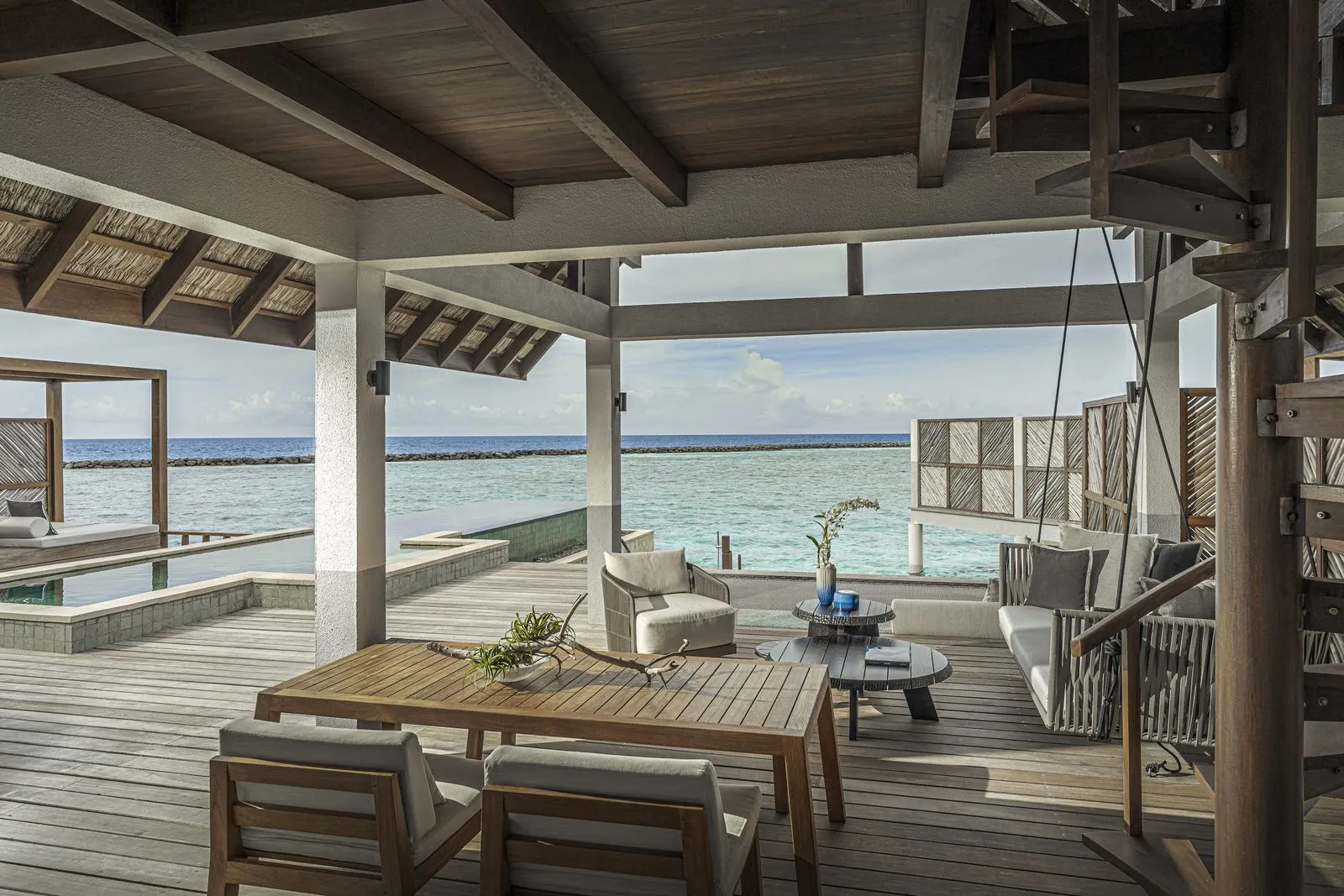 The deck and pool of a Water Villa with Pool – Partial Sea View, the sea beyond