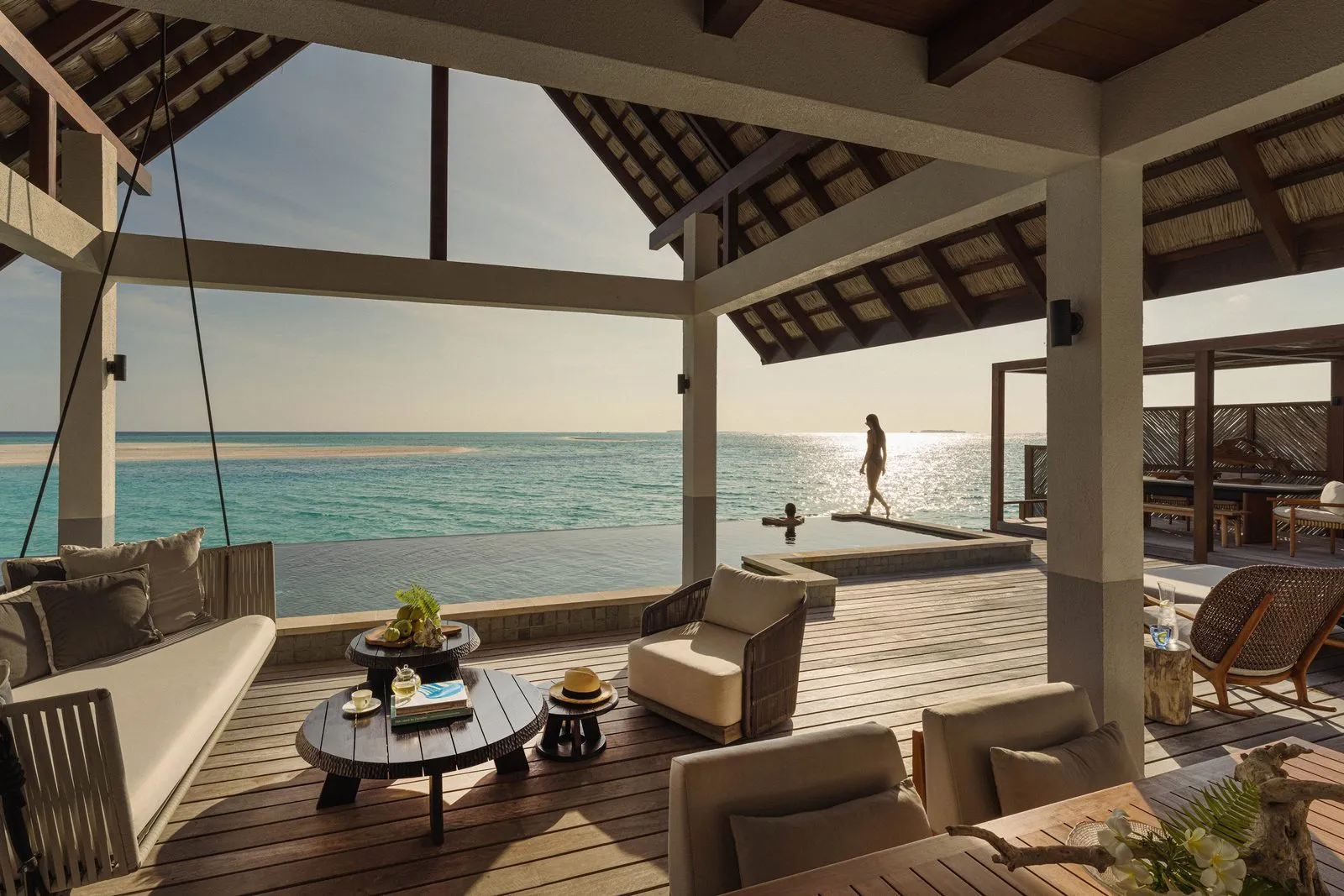 The deck and pool of the Sunset Two-Bedroom Water Suite over the ocean