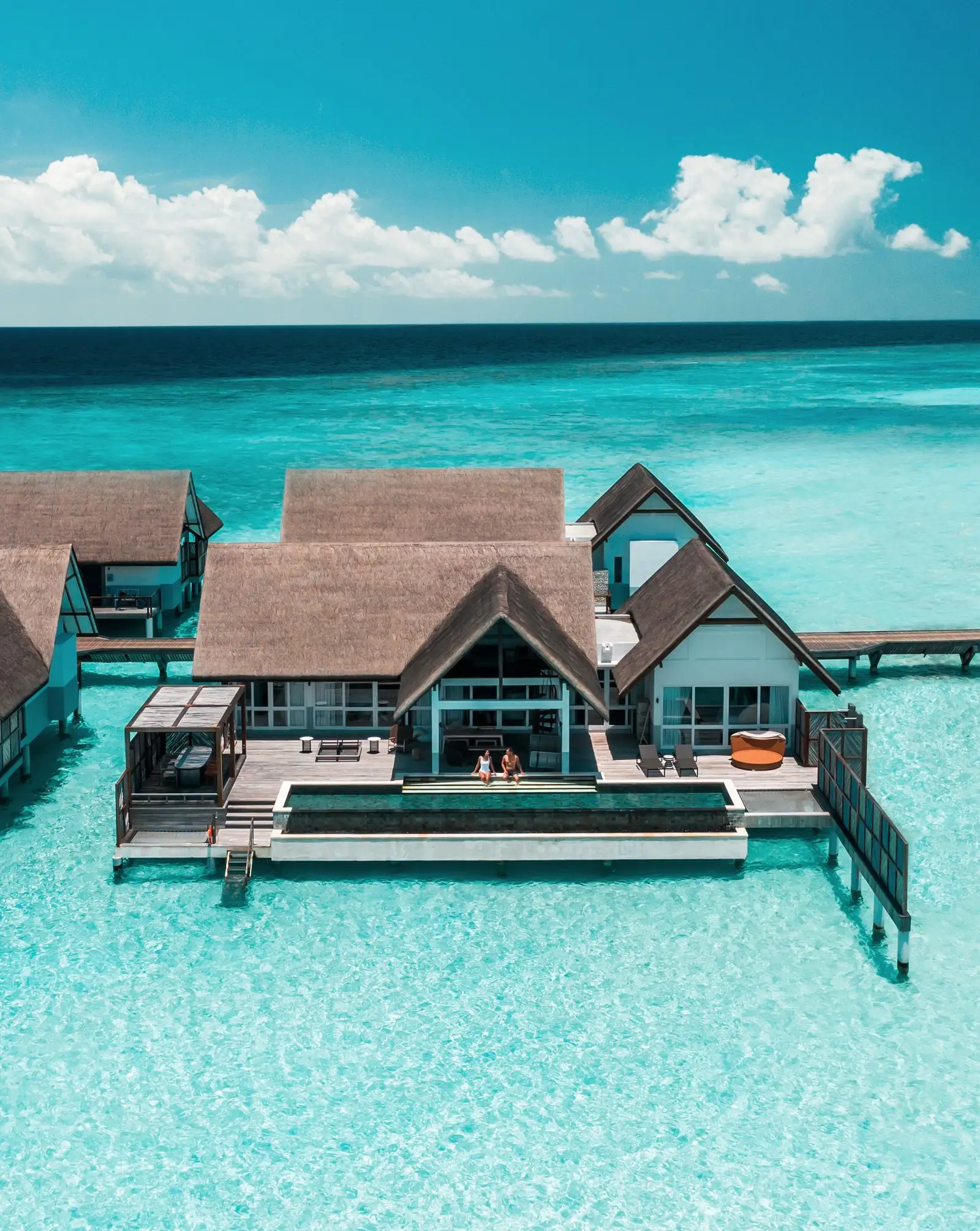 A Sunset Water Villa with Pool from above, its deck over the turquoise lagoon