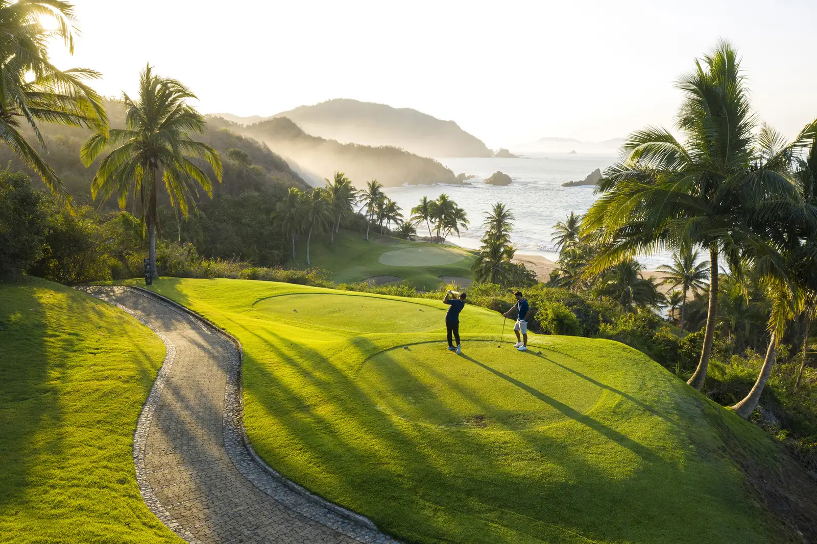 Il campo da golf fra palme e colline davanti al mare