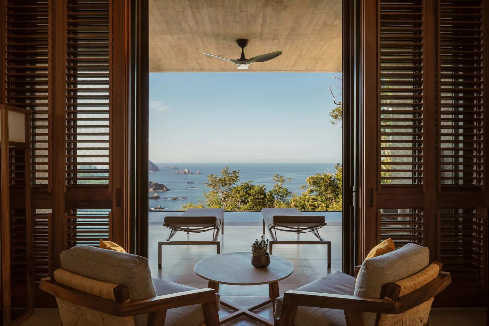 Il soggiorno della Cliffside Ocean-View Suite e il mare oltre la terrazza