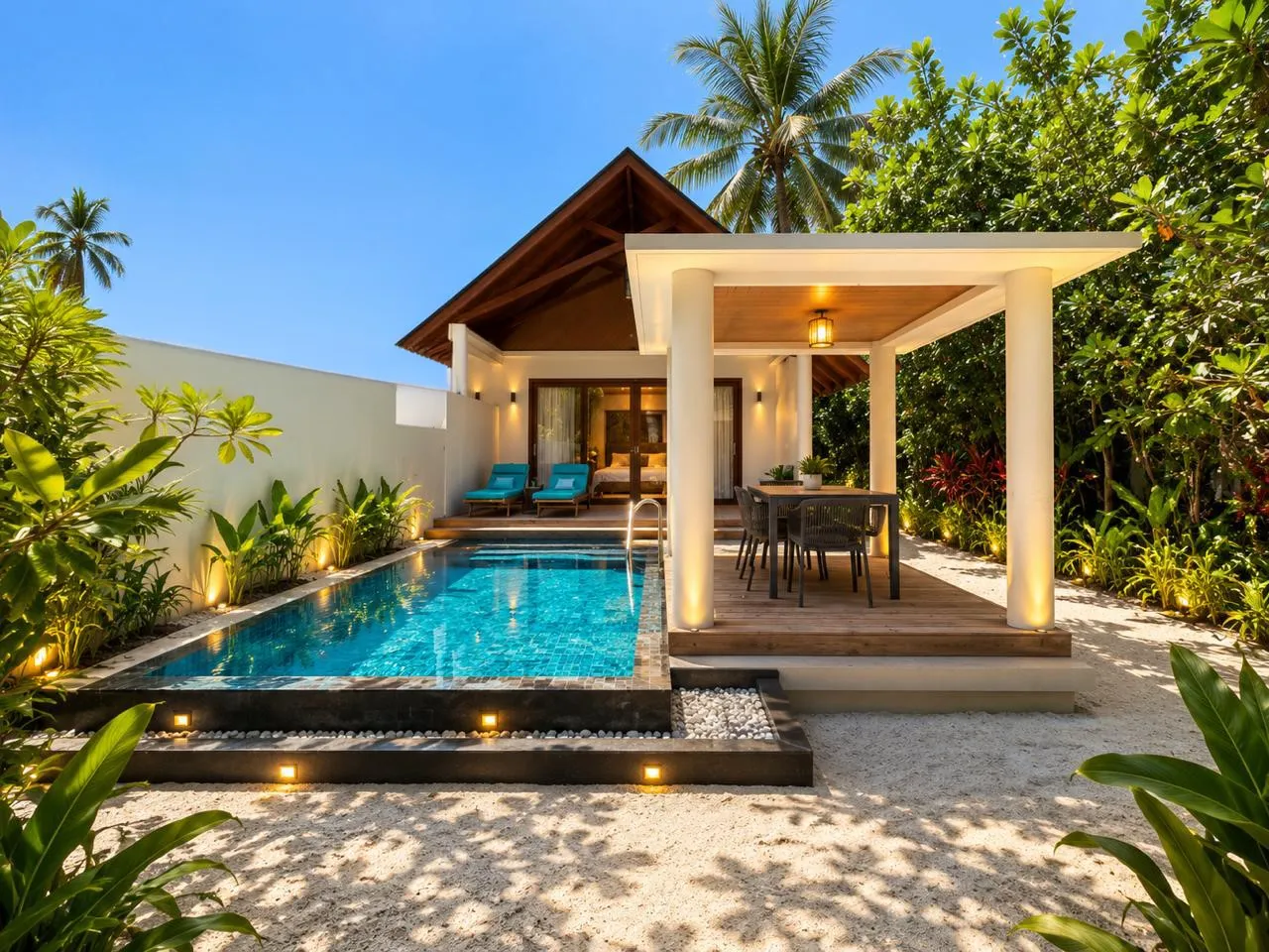An Island Pool Villa’s lit pool between high walls, the gazebo beside it