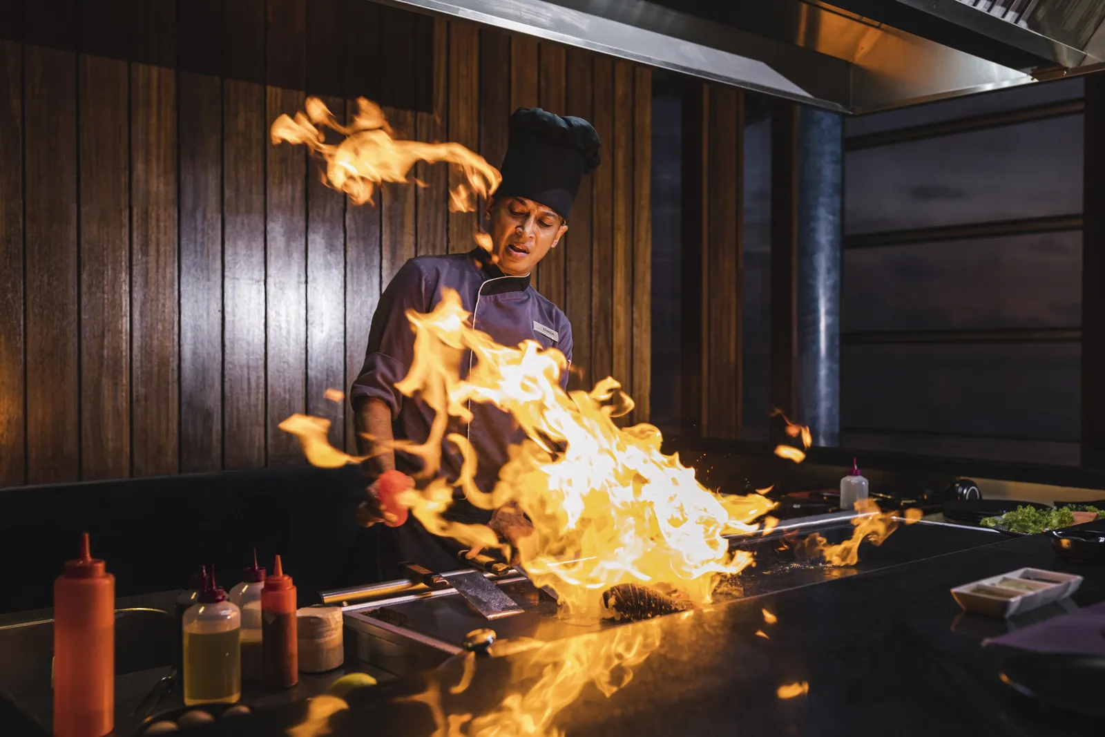 A Teppan De Oishi chef behind the flames of the griddle