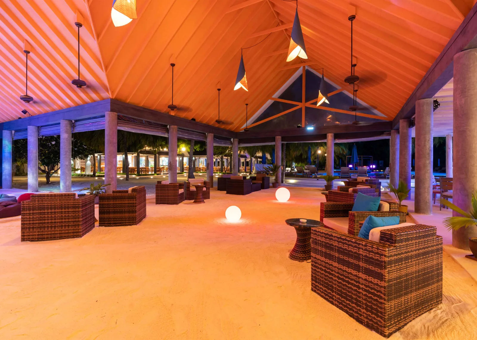 Udhares Bar in the evening, armchairs on the sand under the timber roof