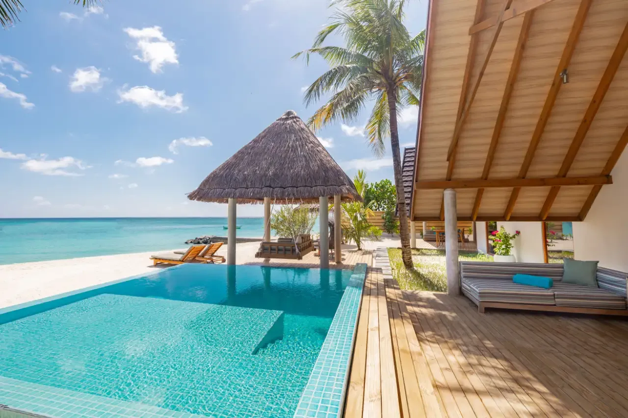 The pool of a Premium Beach Duplex Villa facing the beach and its thatched sala.