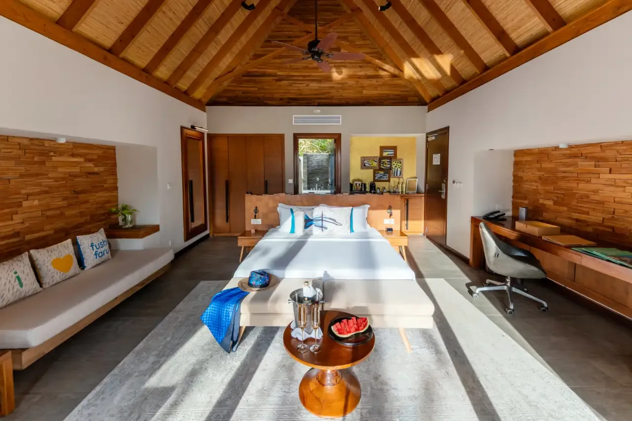 A Beach Villa bedroom with a king bed, a window seat and a timber ceiling.