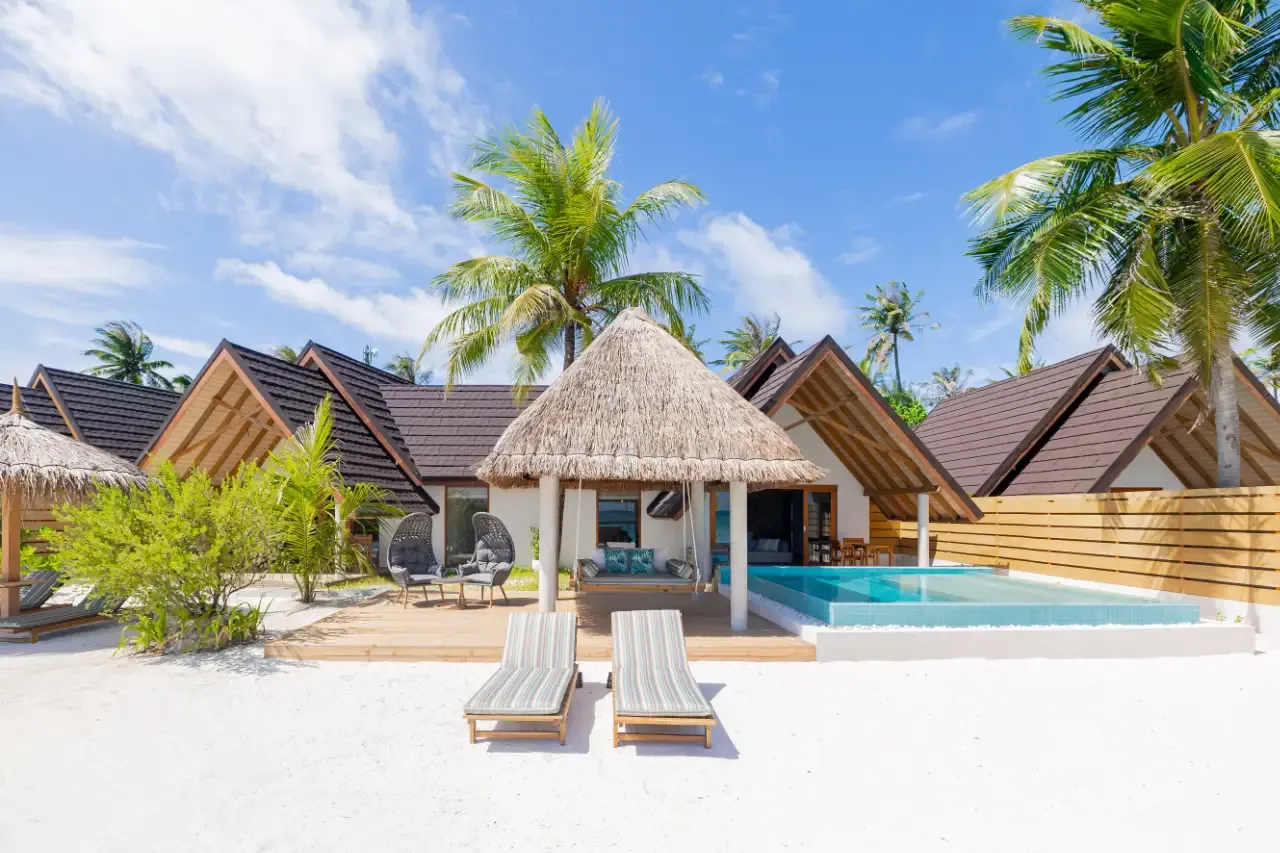A Premium Beach Duplex Villa with its thatched sala, pool and loungers on the sand.