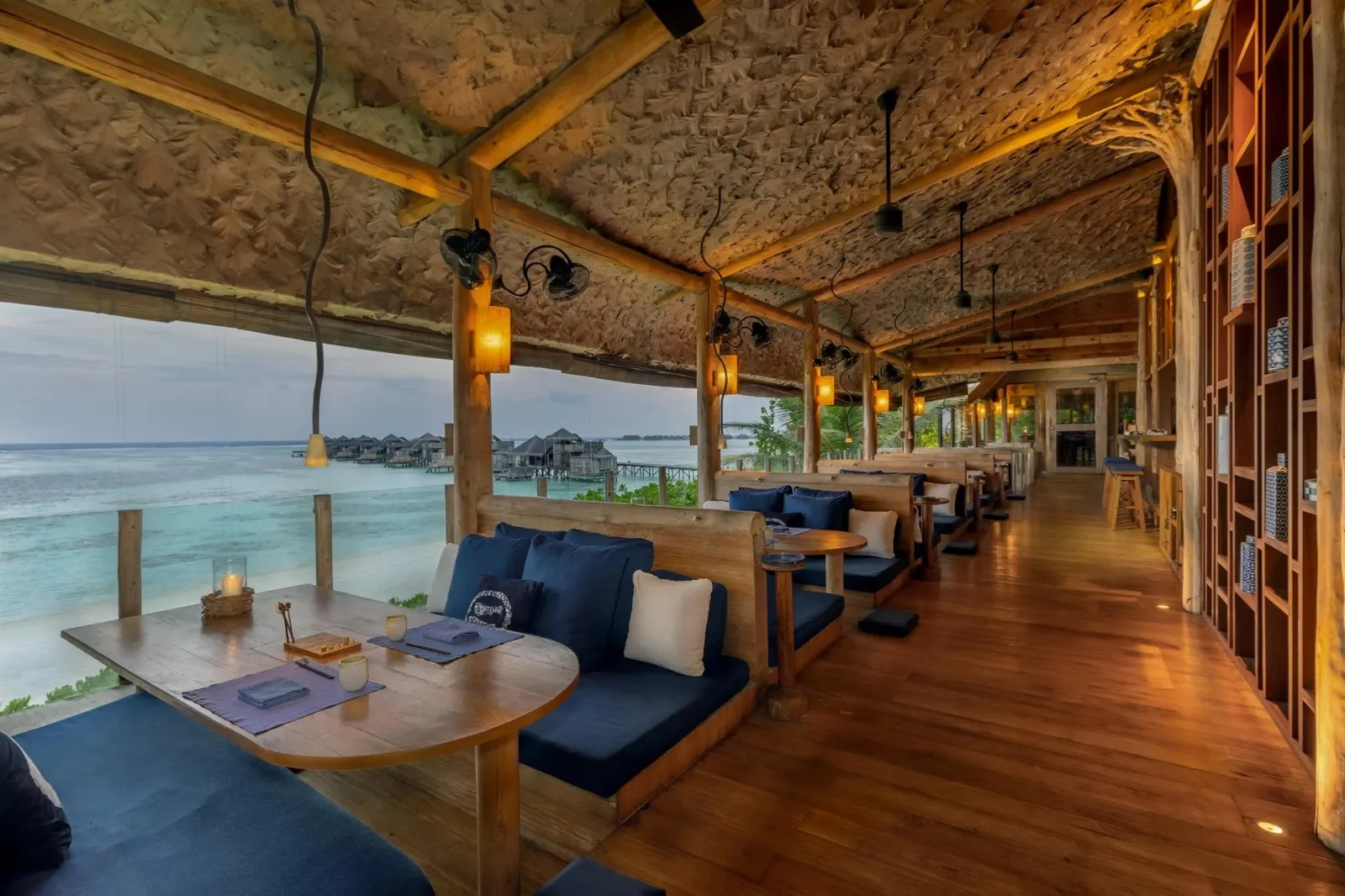 By The Sea’s dining room, dark wood and tables facing the sea