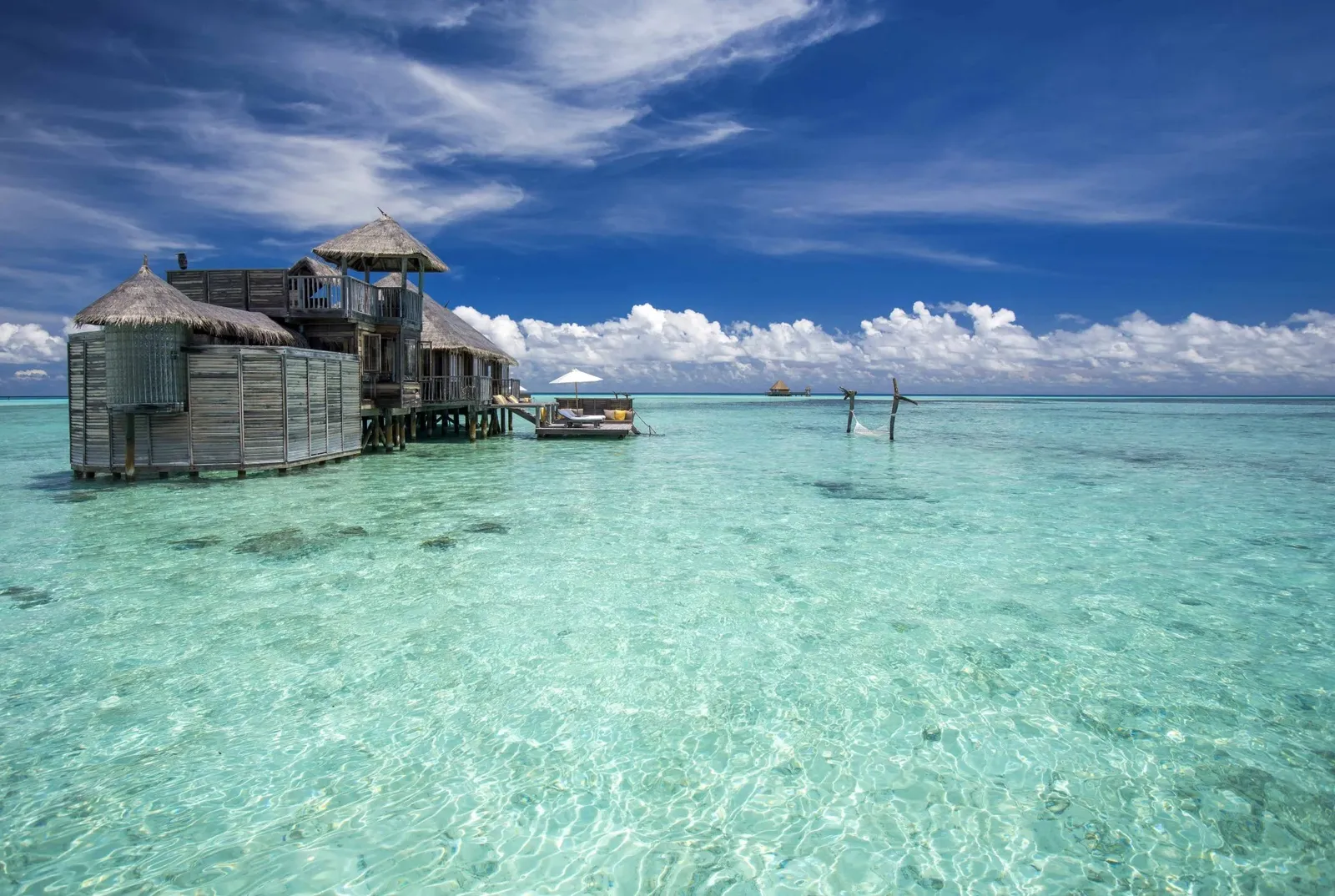 A Crusoe Residence alone in the lagoon, its hammock strung over the shallows